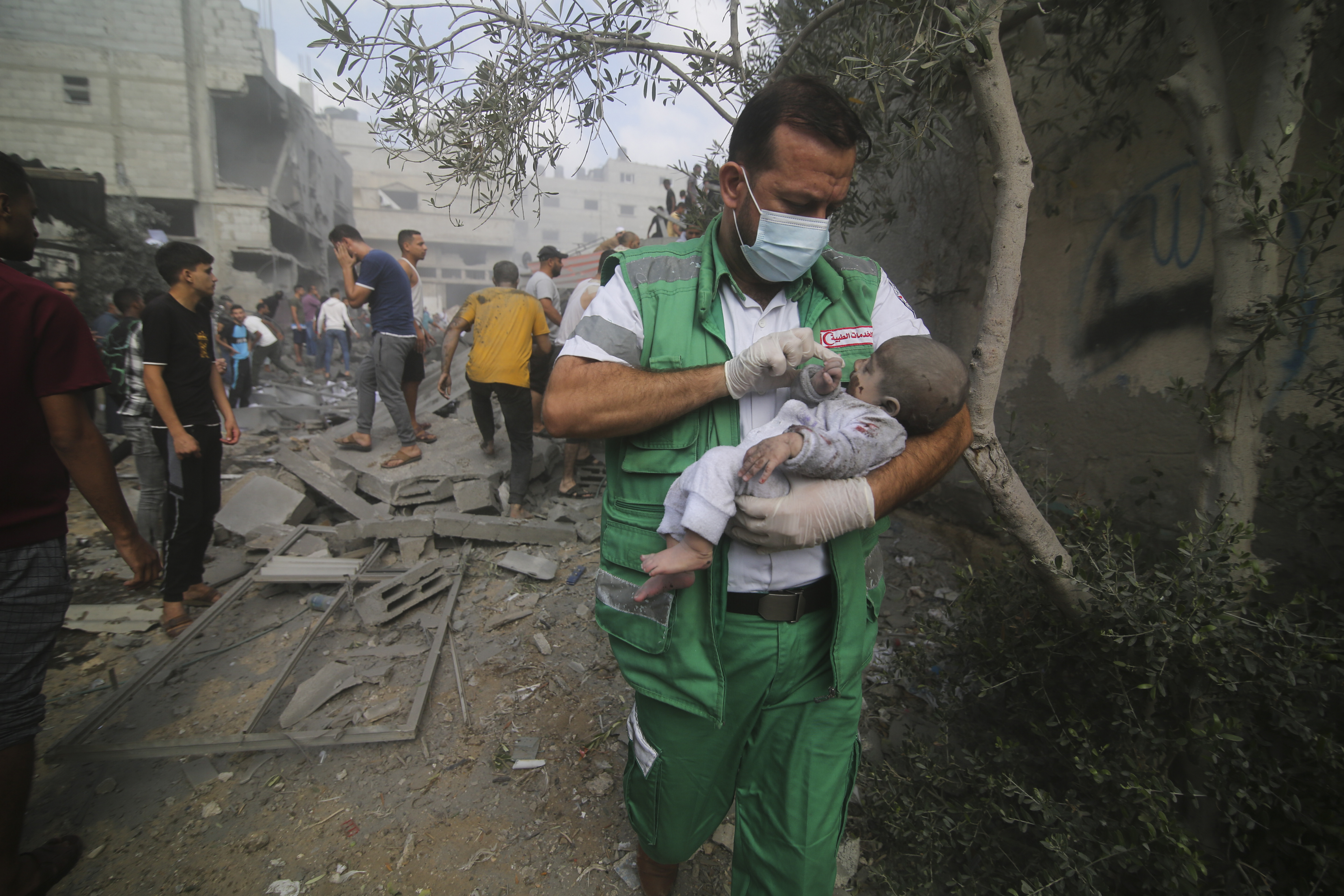 A Palestinian medic takes a baby pulled out of buildings destroyed in the Israeli bombardment
