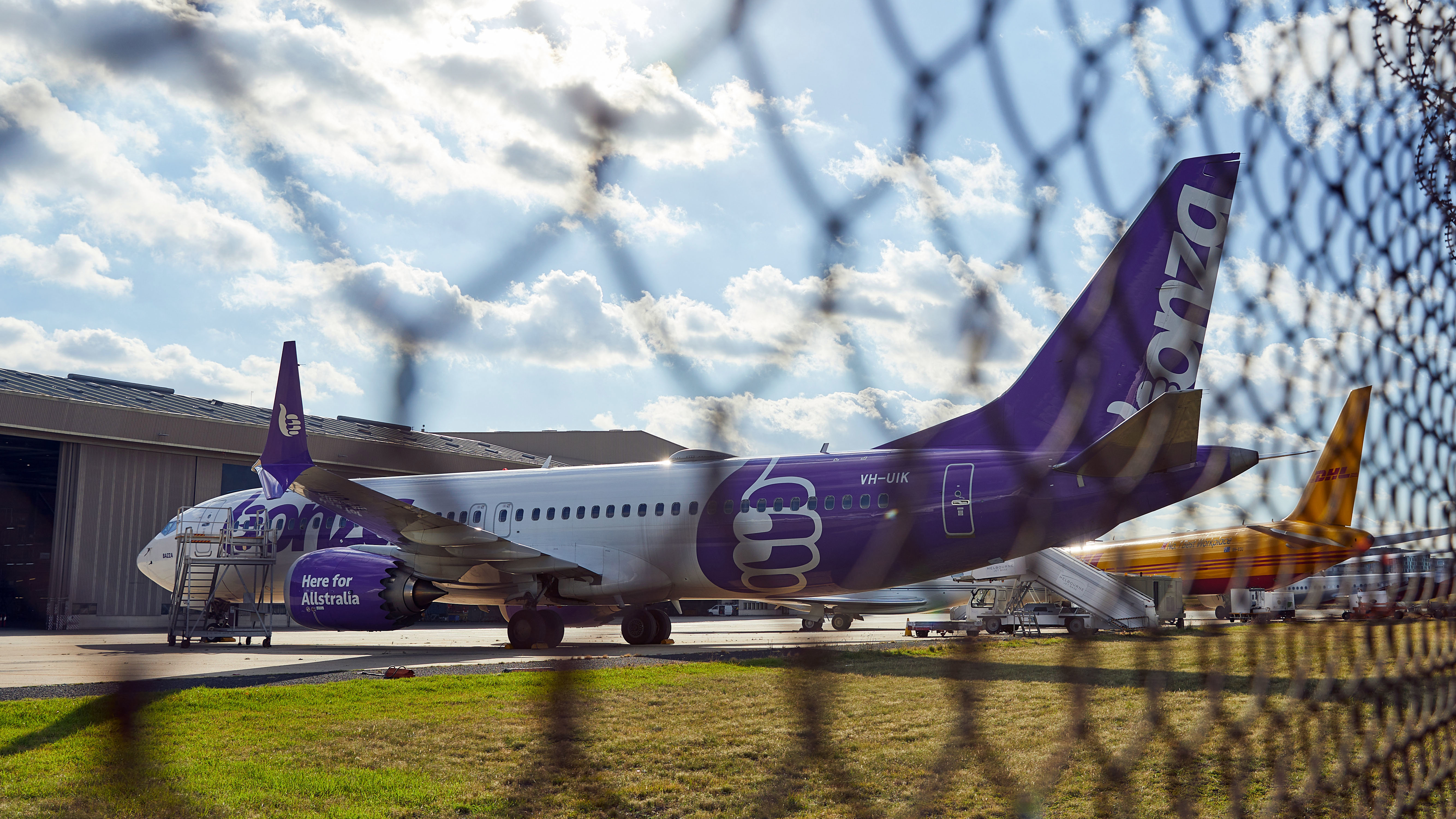 A Bonza plane behind a wire fence.