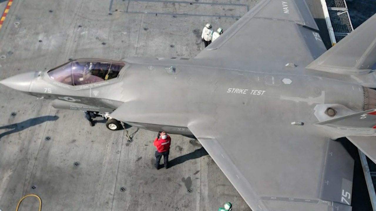 The warplane was impacted by the flight deck of the 100,000-ton aircraft carrier and then fell into the water as its pilot ejected. 