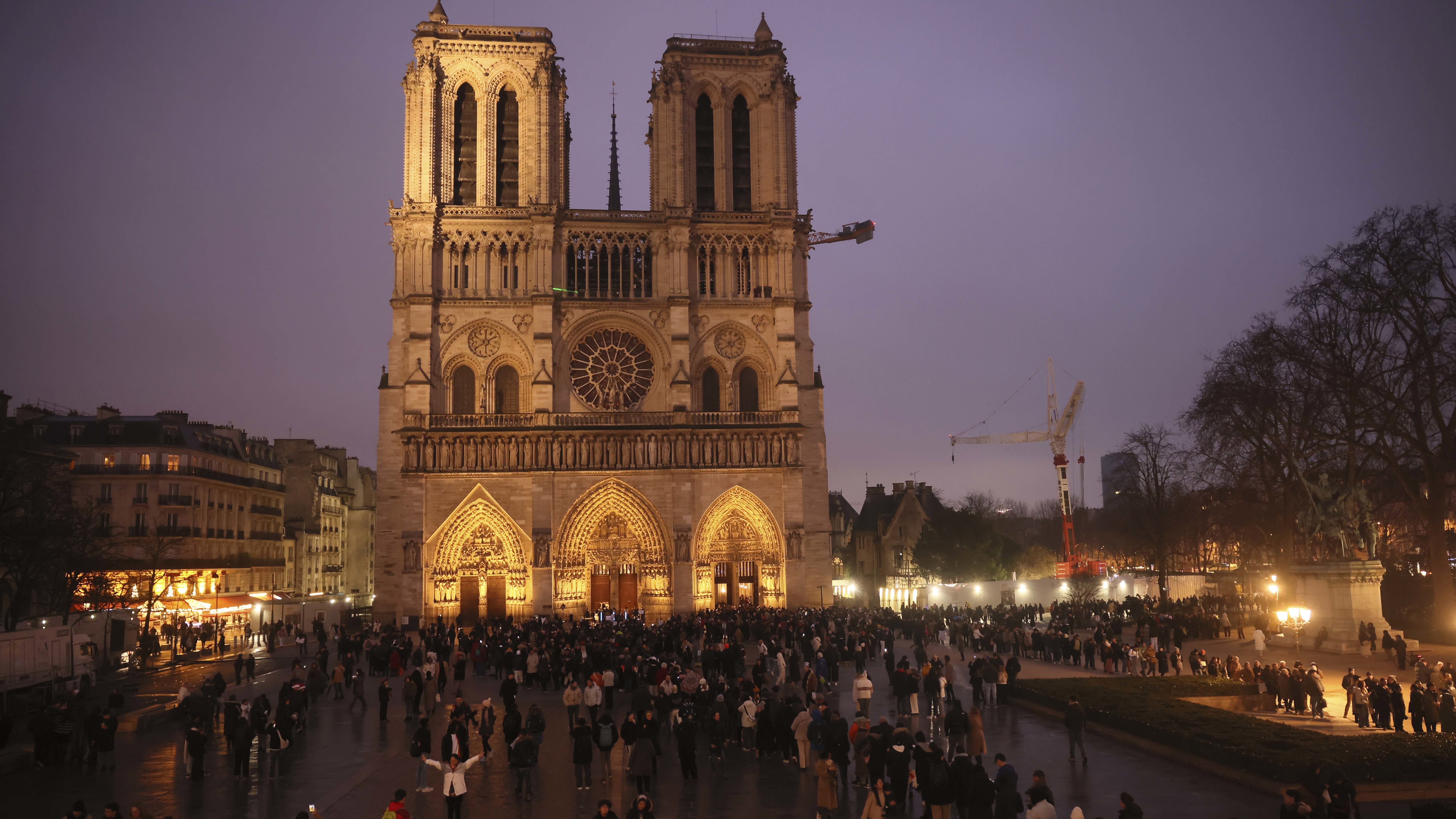 People queue to attend the mass at Notre Dame Cathedral as the monuments hosts Christmas Eve services for the first time since a devastating 2019 fire, Tuesday, Dec. 24, 2024 in Paris. (AP Photo/Thomas Padilla)