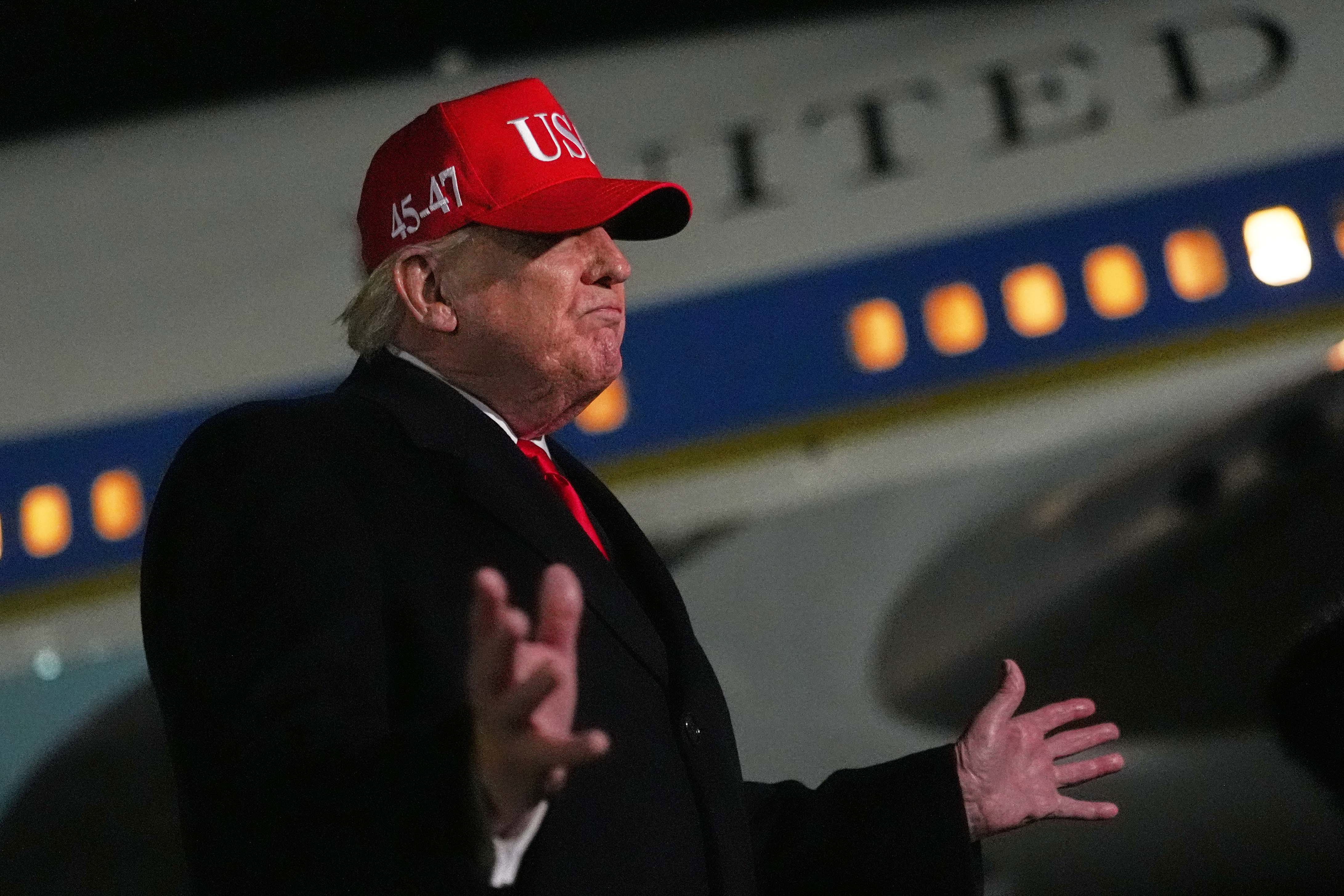 President Donald Trump speaks with reporters at Joint Base Andrews, after he returned from Miami. 