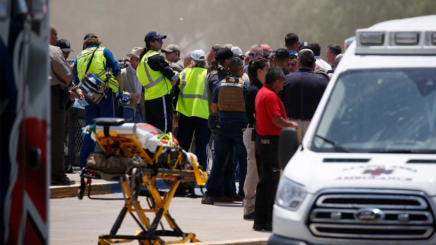 Los servicios de emergencia y los lugareños se reúnen frente a la Escuela Primaria Robb en Uvalde, Texas.