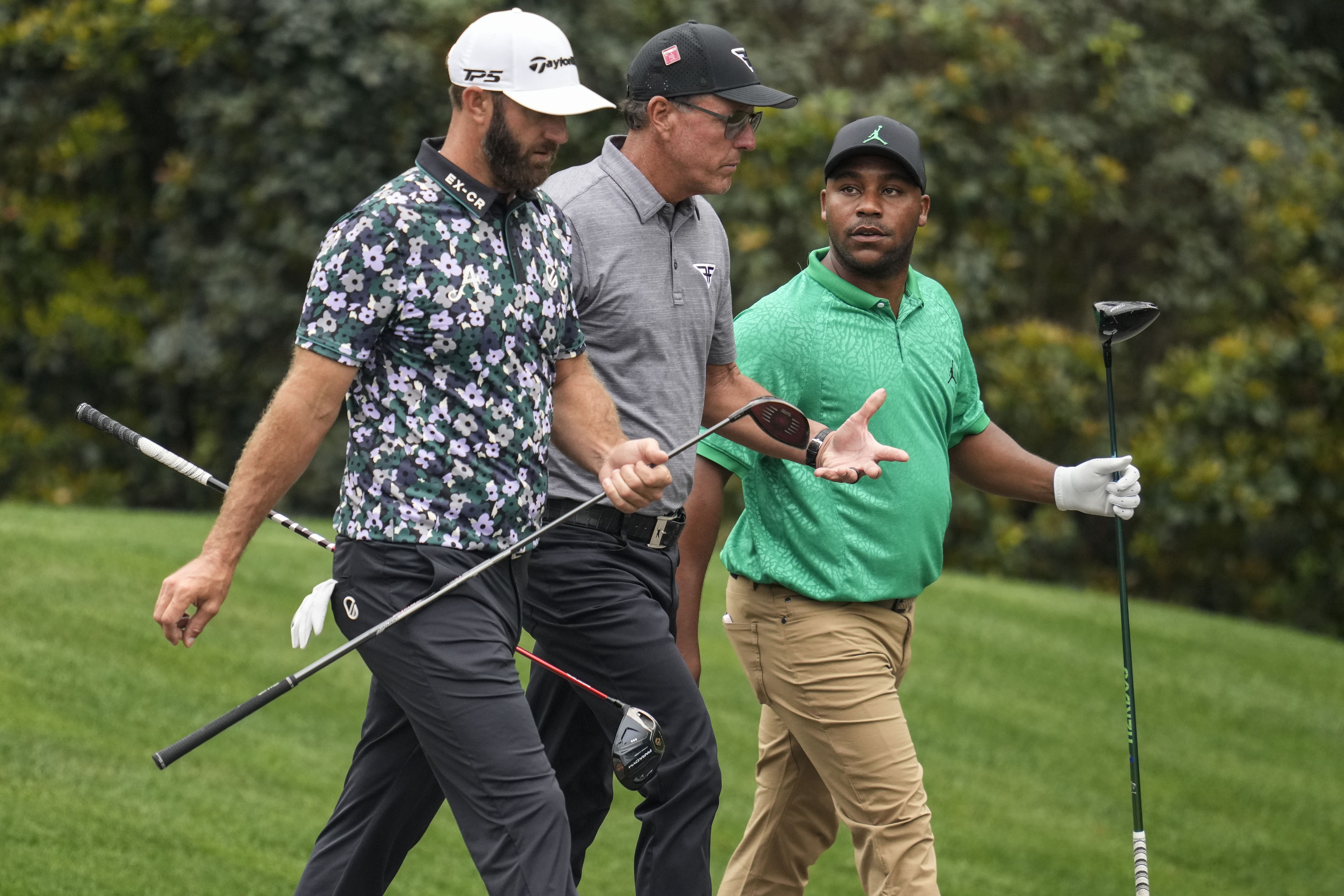 Dustin Johnson, Phil Mickelson, and Harold Varner III, walk on the 11th fairway at Augusta National.