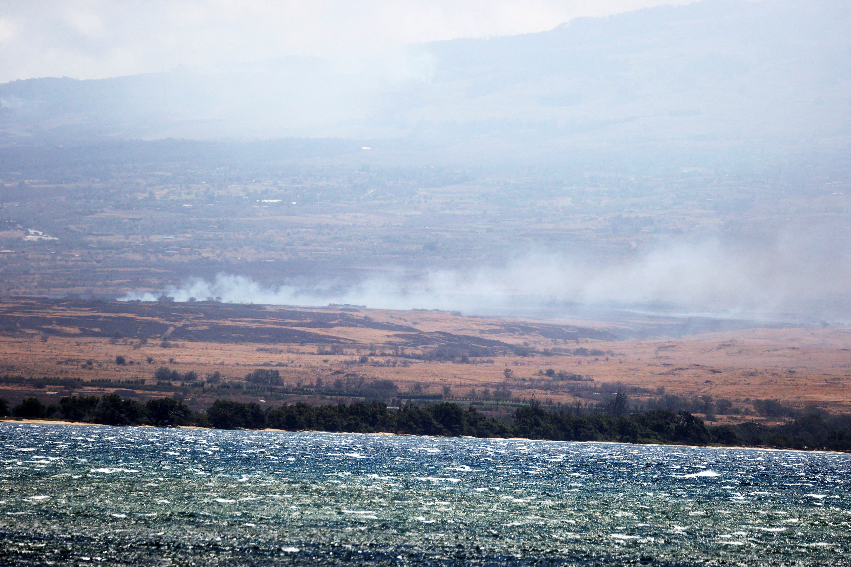 Wildfires are seen across Maalaea Harbor due to high winds in Maui believed to have destroyed much of the historic town of Lahaina, Hawaii, in Kahului, Hawaii, U.S. August 9, 2023. REUTERS/Marco Garcia