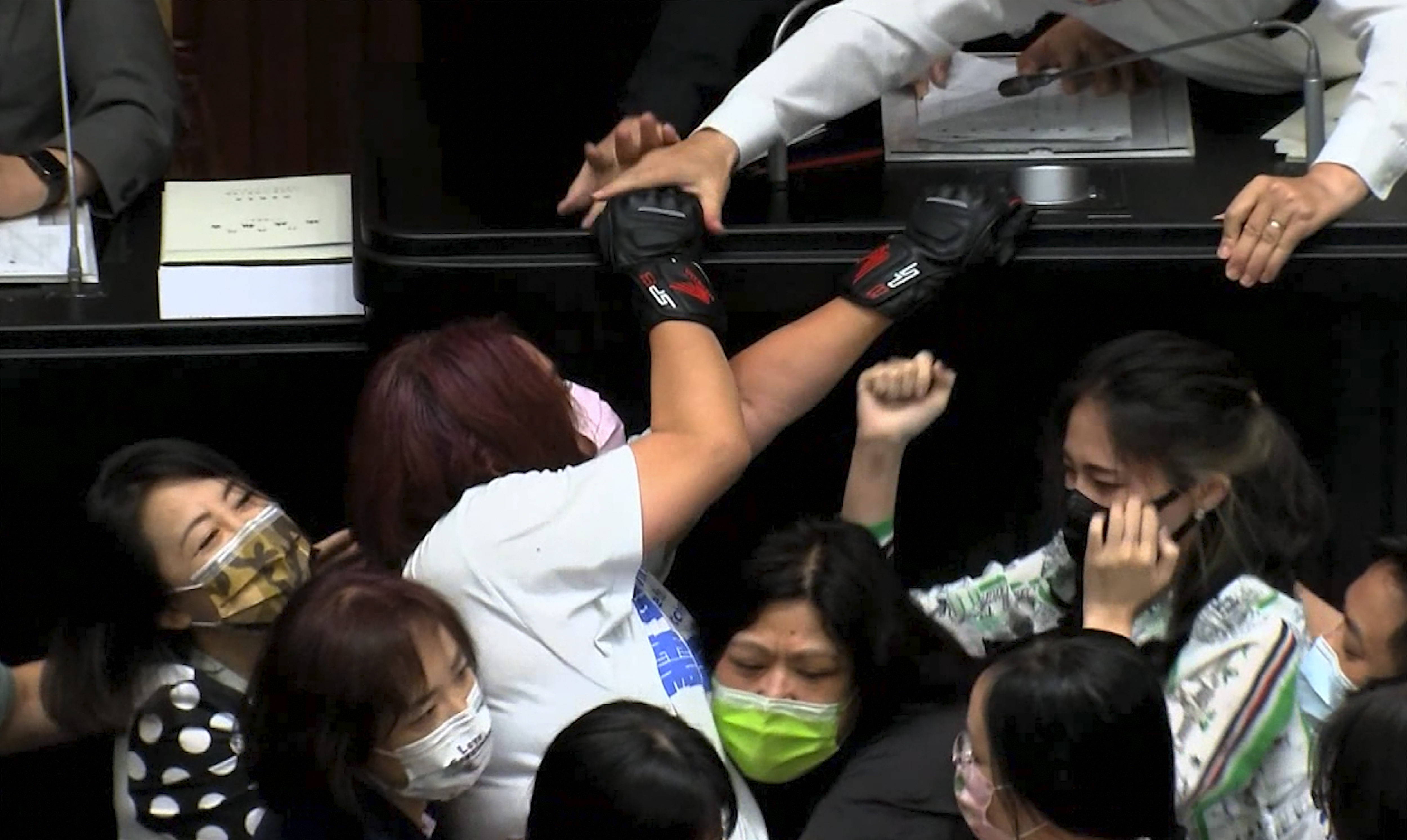 Opposition Nationalist party lawmaker Chen Yu-jen, in white shirt, is grabbed by ruling Democratic Progressive Party lawmakers as she tries to climb onto the podium during a parliament session in Taipei. 