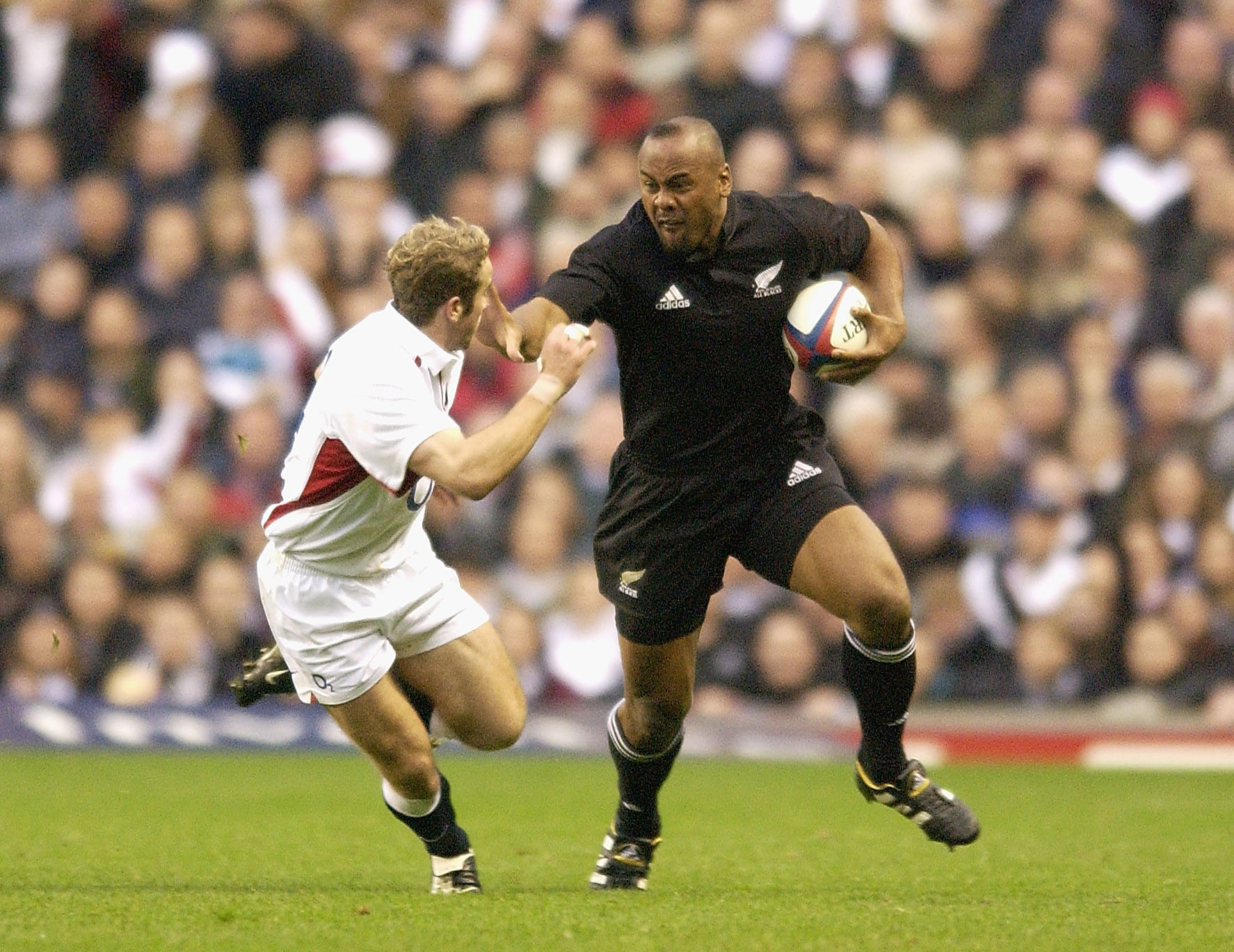 Jonah Lomu of New Zealand goes past James Simpson-Daniel of England.