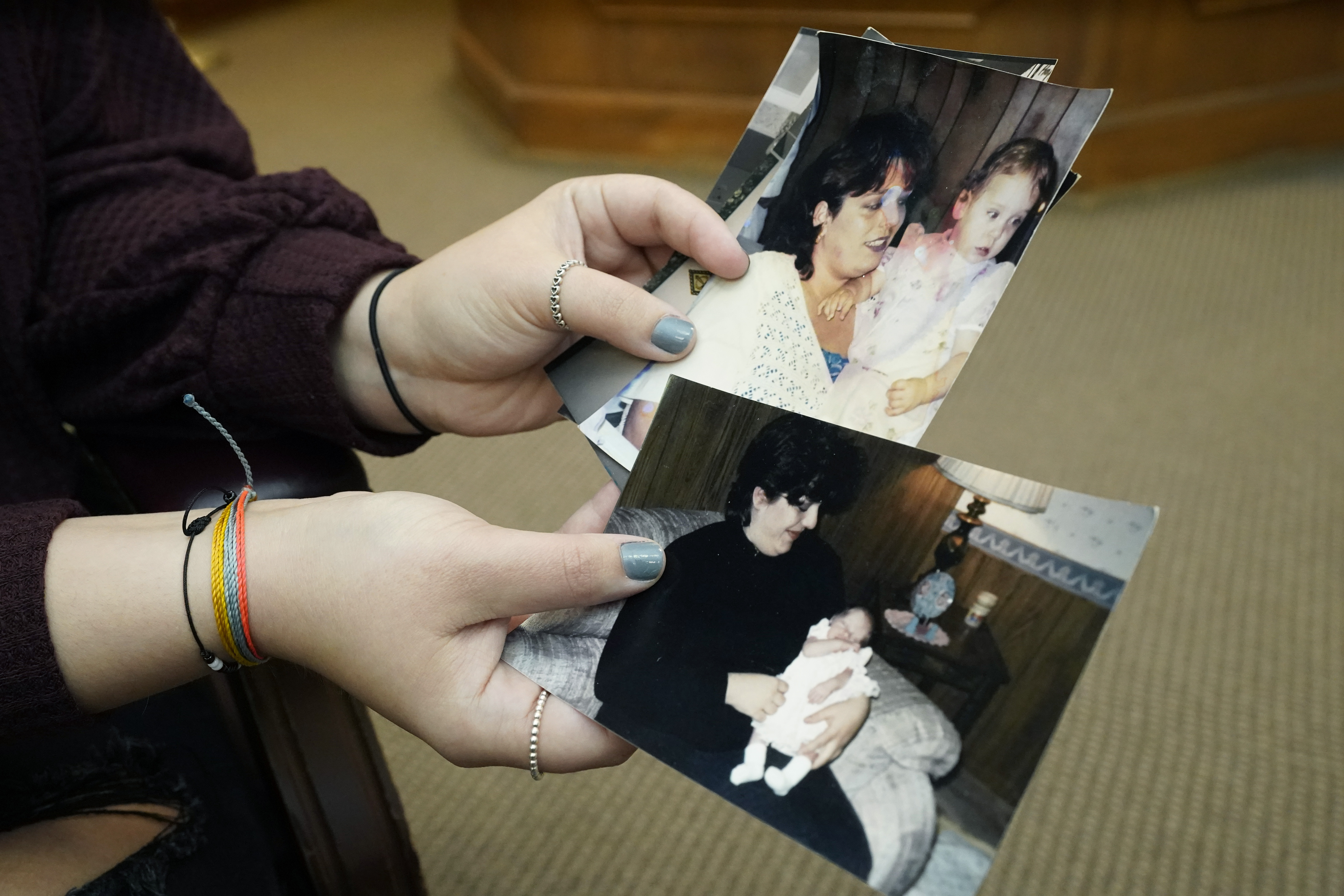 Lindsey Kirk shows childhood photographs of herself and her late mother Kim Kirk Cox.