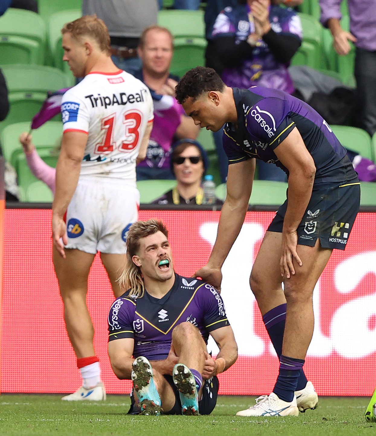 Ryan Papenhuyzen of the Storm is injured after scoring a try against the Dragons.