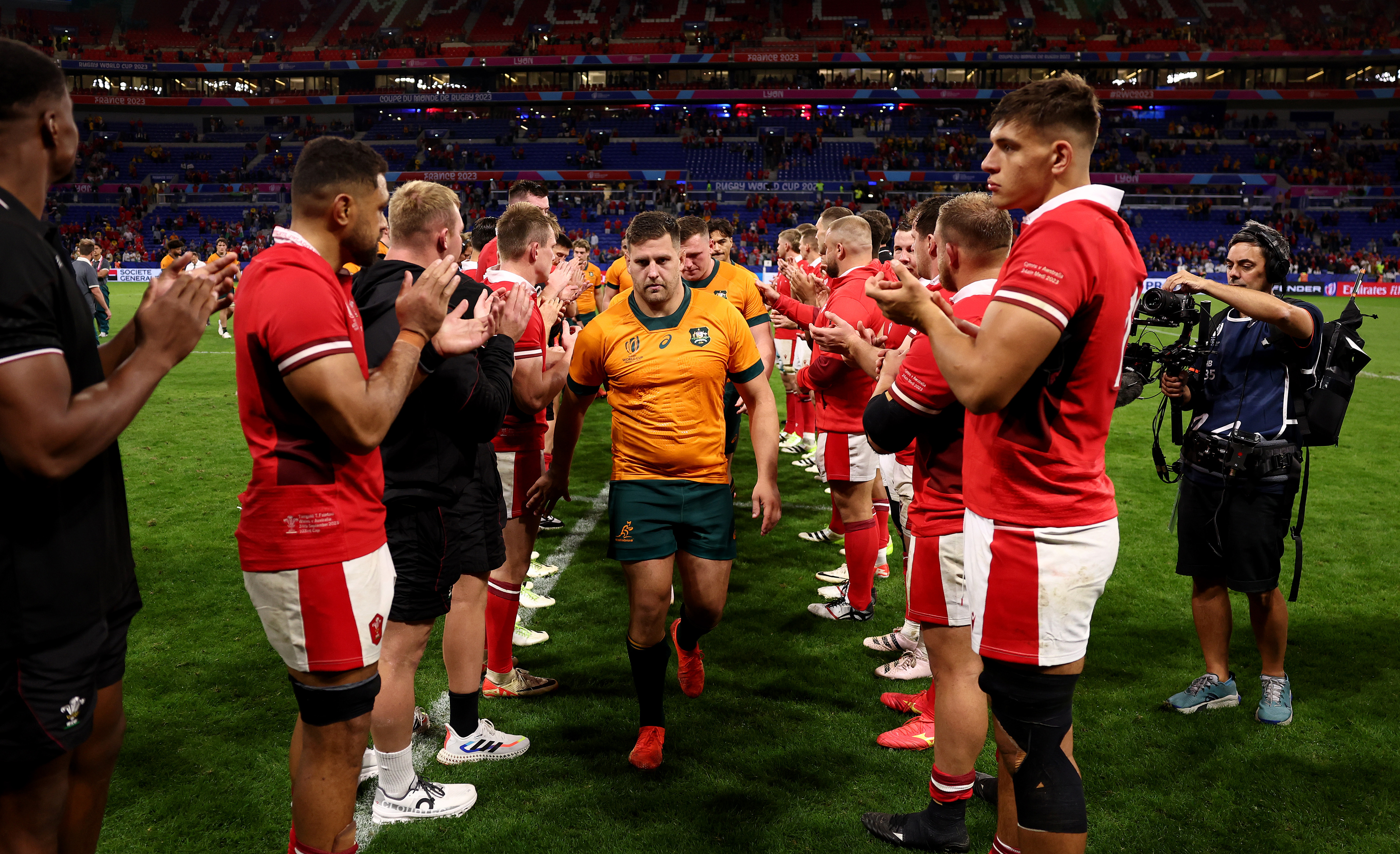 The players of Wales give the players of Australia a guard of honour as they leave the pitch at full-time.