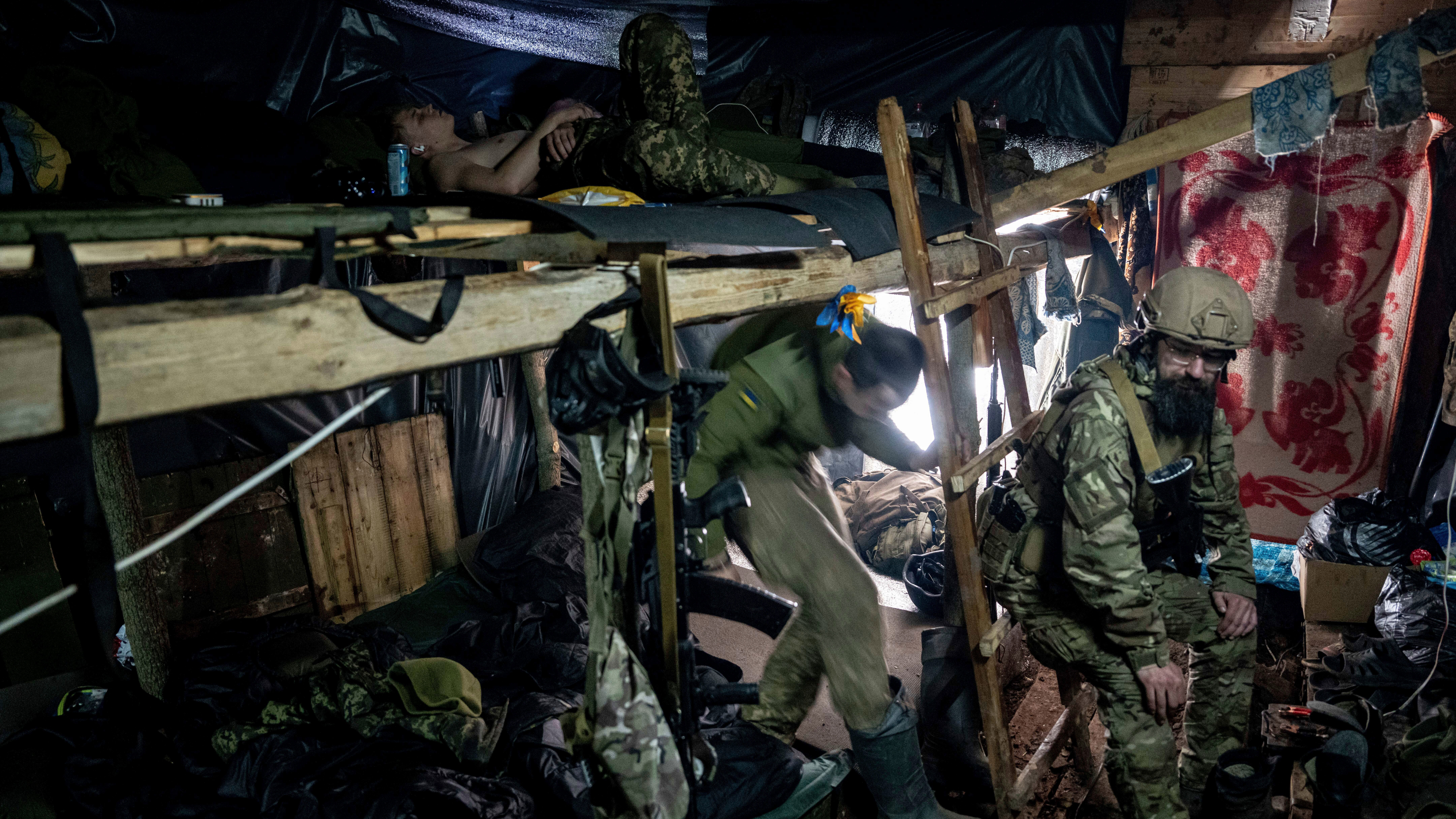 Ukrainian paratroopers of 80 Air Assault brigade rest inside a dugout at the frontline near Bakhmut, Ukraine.