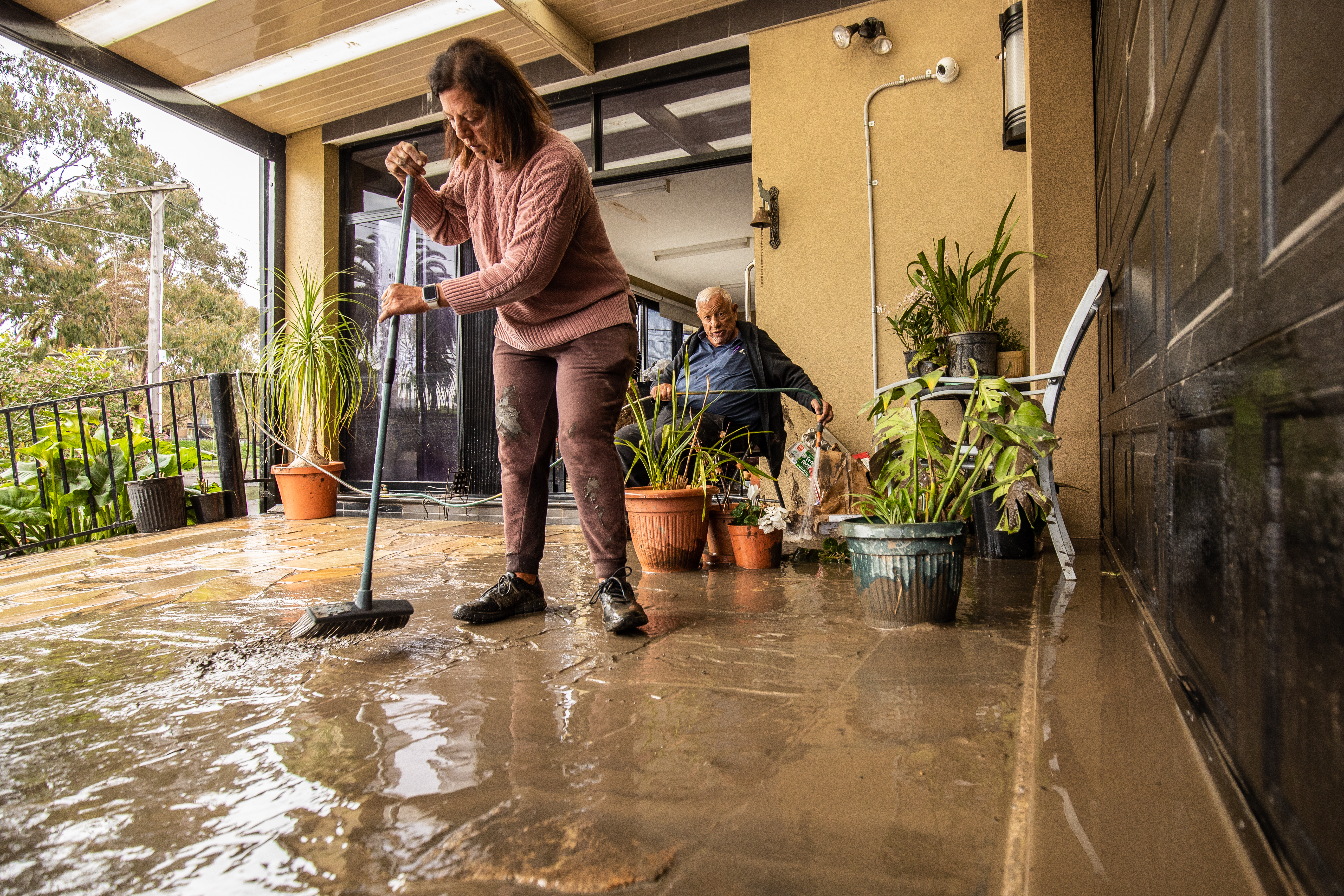 Photo shows Solly and his daughter Serine cleaning up after the flooding of the Maribyrnong River. Solly has lived on Chifley Drive for 15 years and says this is by far the worst flood he has seen here. 