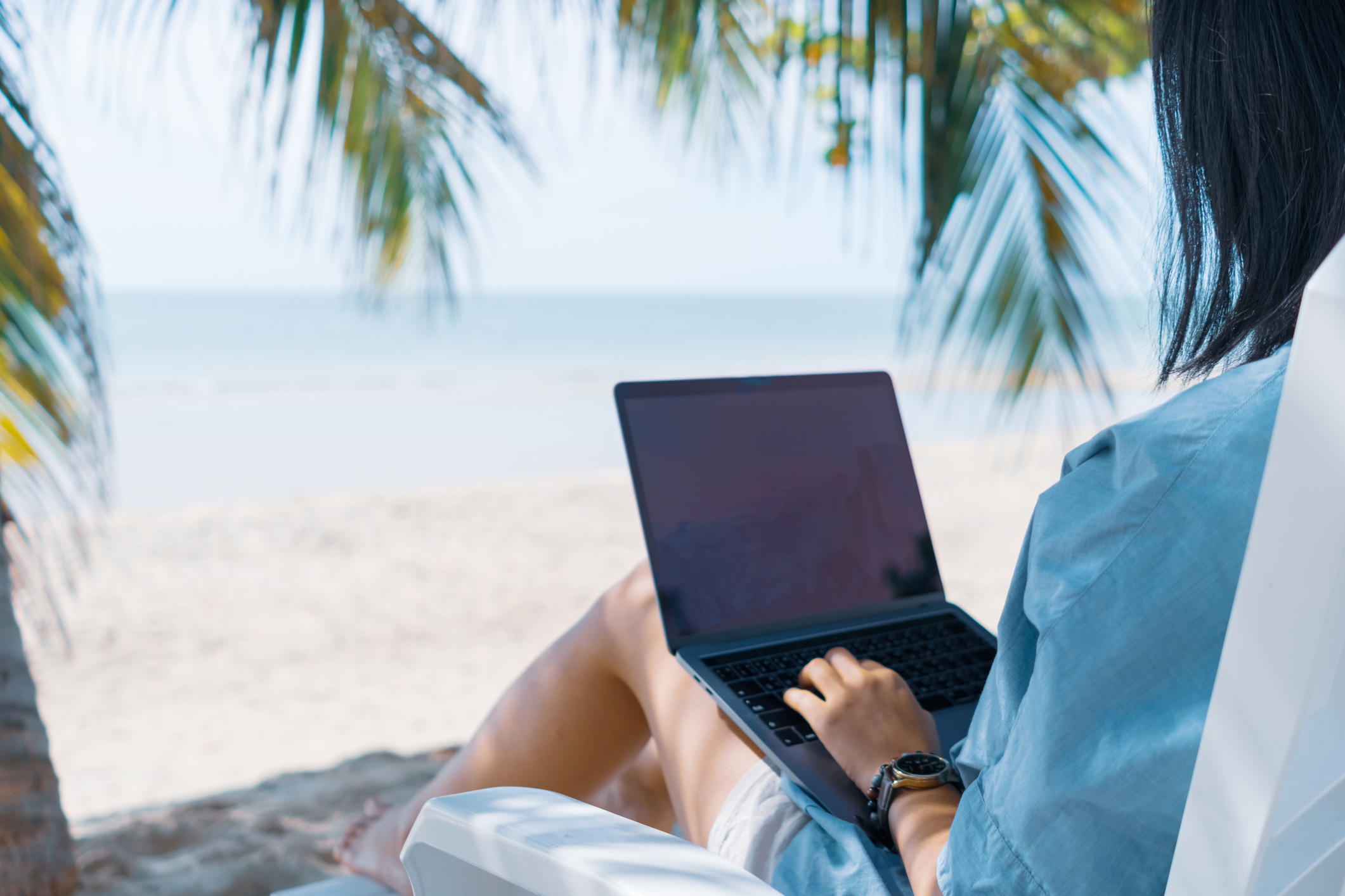 Woman using laptop and smartphone to work study in vacation cady at beach background. Business, financial, trade stock maket and social network concept.