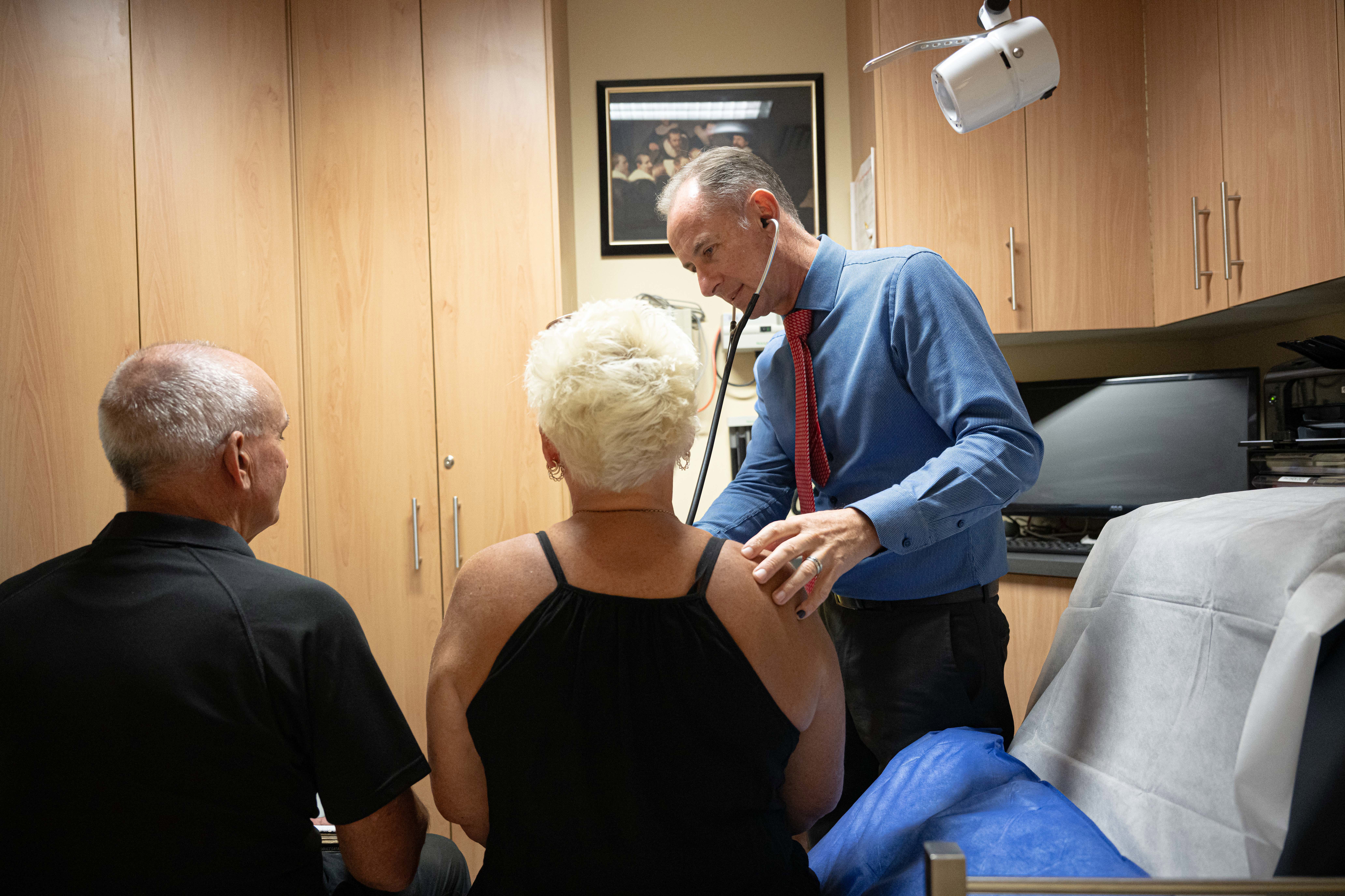 A GP during an appointment with two patients.