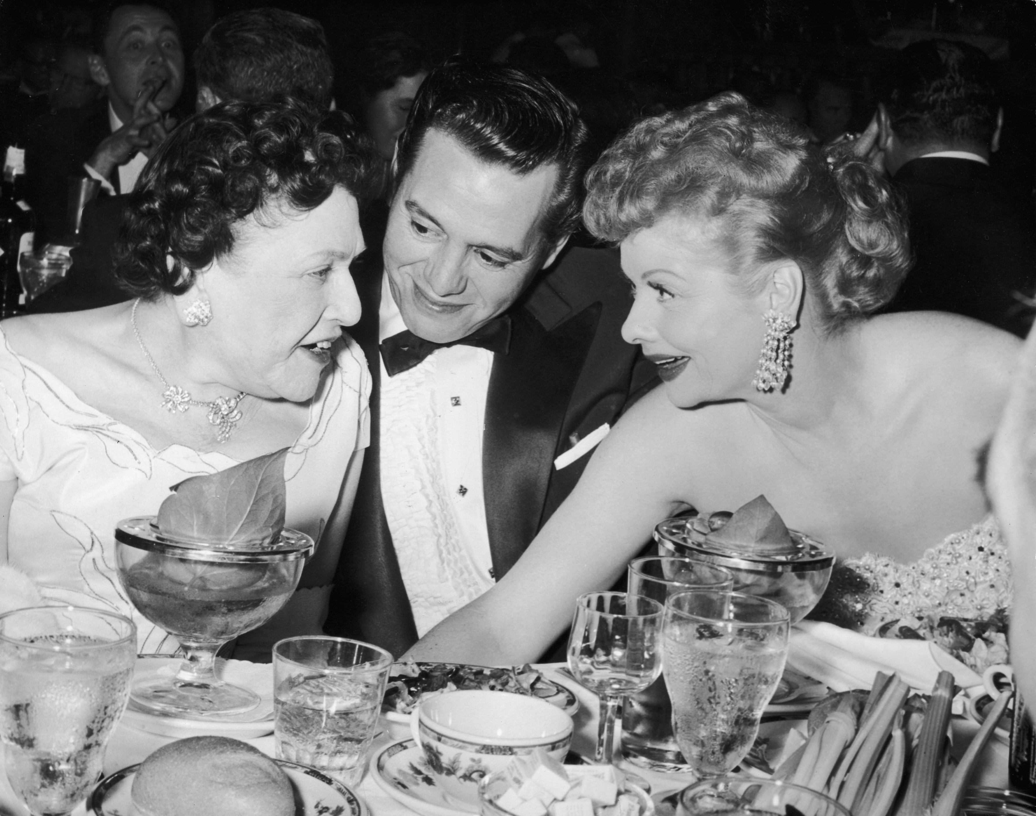 Desi Arnaz and Lucille Ball chat with Hollywood gossip columnist Louella Parsons (left) at the Golden Globe Awards in 1956.