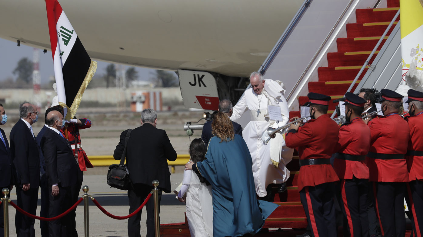 Pope Francis walks down the steps of an airplane as he arrives at Baghdad international airport, Iraq, Friday, March 5, 2021