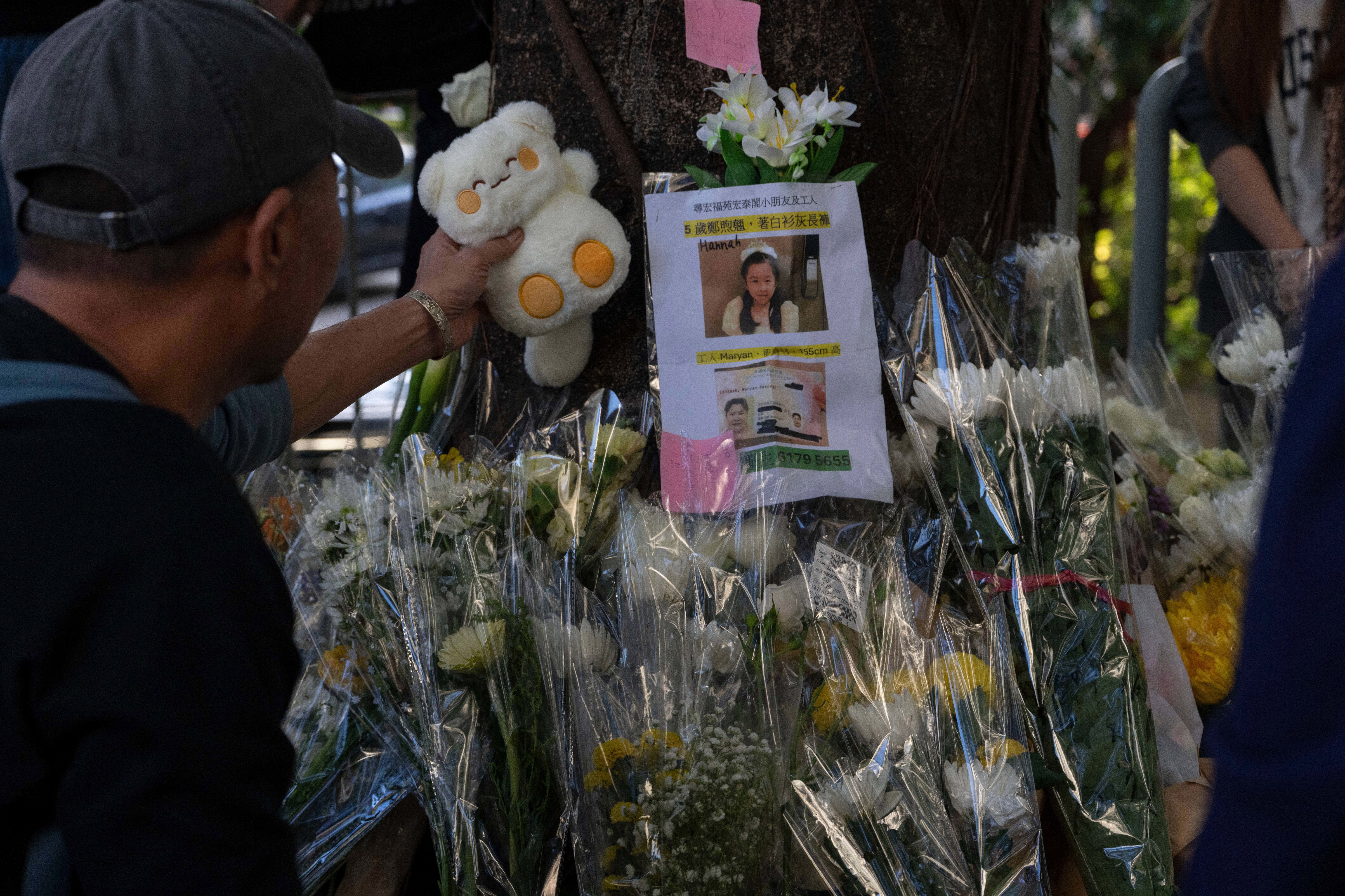 Soft toys and flowers are placed to mourn victims of the deadly fire at Wang Fuk Court.