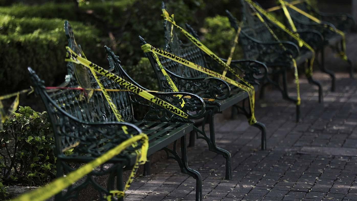Caution tape is looped around park benches to discourage people from sitting on them in the main plaza of Coyoacan, in Mexico City, Saturday, April 4, 2020. 