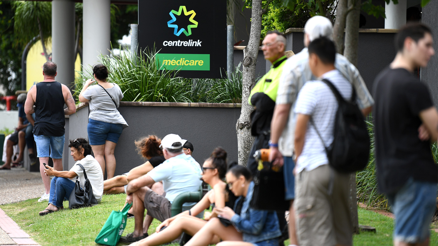 People are seen in long queues outside the Centrelink office in Southport on the Gold Coast. Centrelink offices around Australia have been inundated with people attempting to register for the Jobseeker allowance in the wake of business closures due to the COVID-19 pandemic.