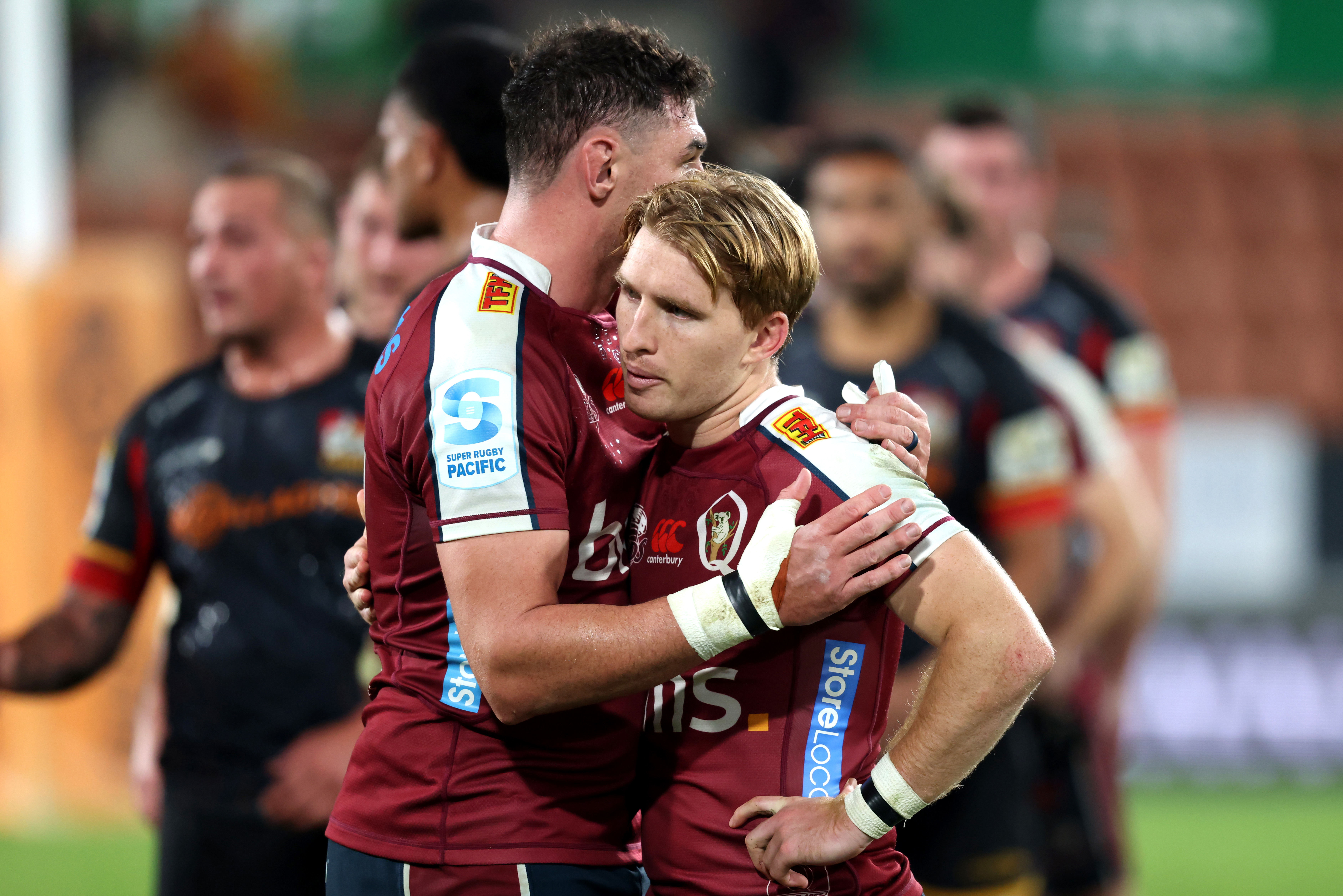 Connor Vest consoles Reds captain Tate McDermott after losing the Super Rugby Pacific quarter-final against the Chiefs in Hamilton.