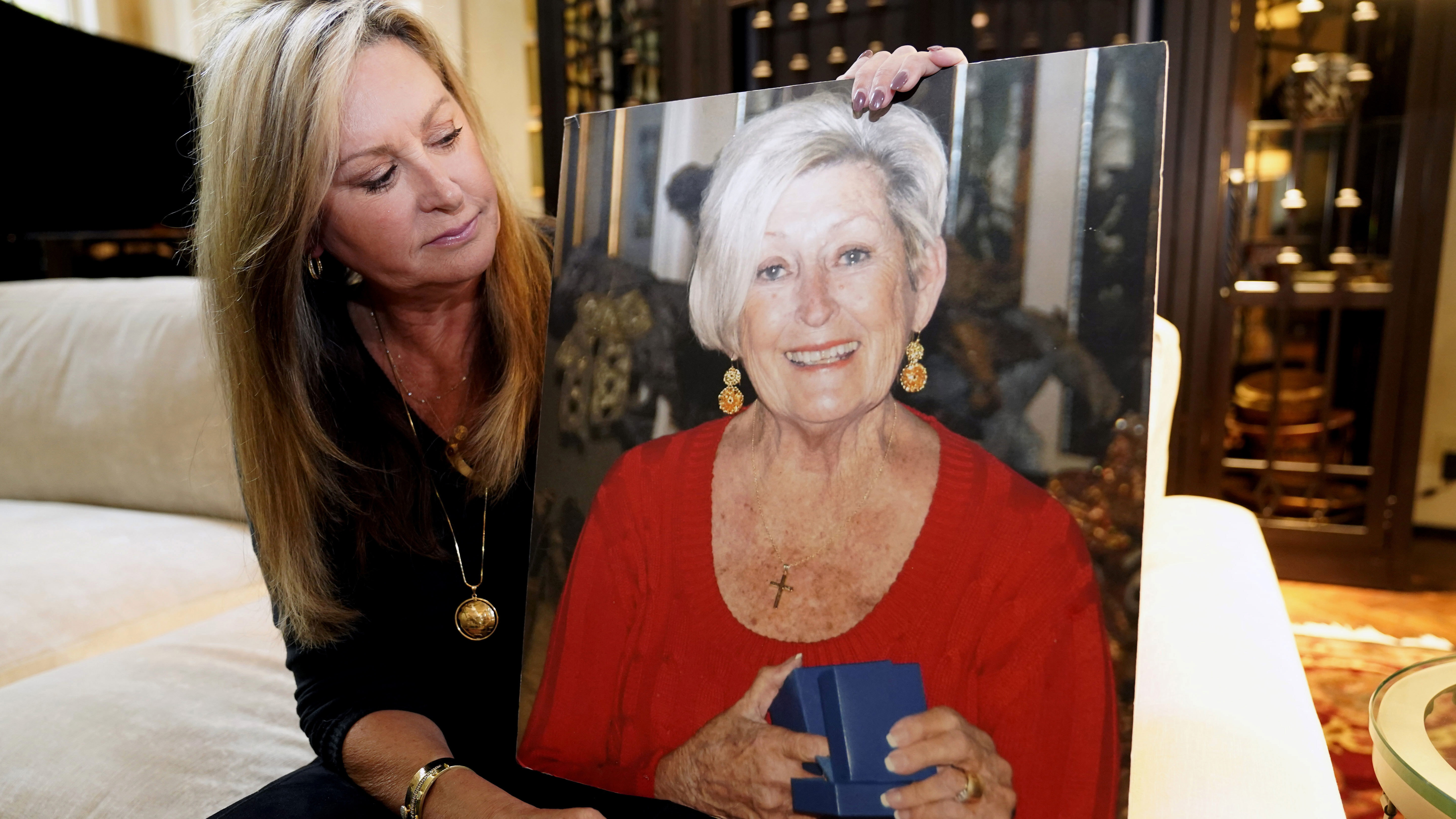 M.J. Jennings looks at a photo of her mother Leah Corken while sitting at her home in Dallas, Wednesday, Nov. 3, 2021. Corken was one of 22 women in the Dallas area who Billy Chemirmir was charged with killing.