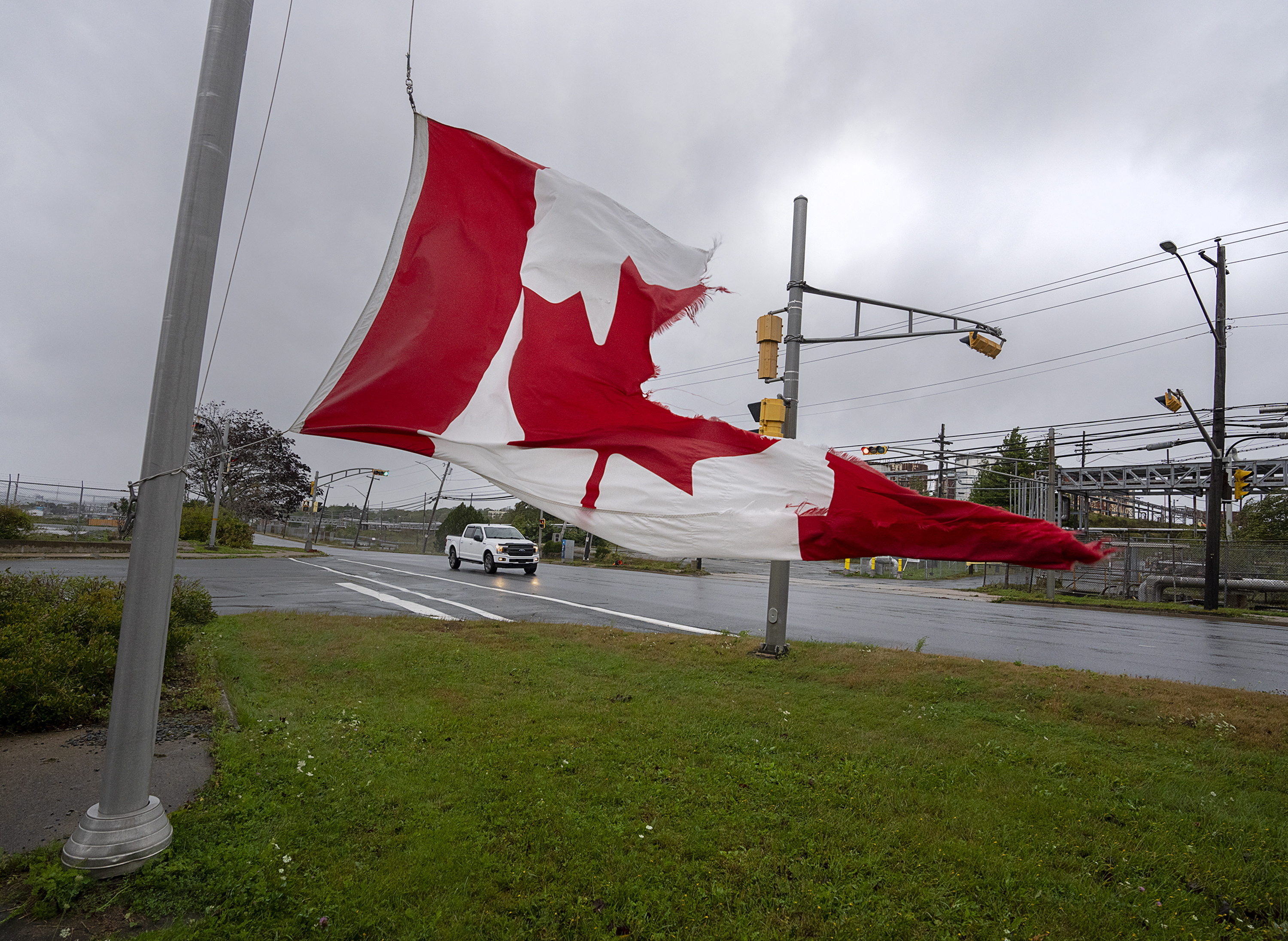 A Canadian flag waves in the high winds in Dartmouth, N.S. on Saturday, Sept. 24, 2022.    (Andrew Vaughan /The Canadian Press via AP)