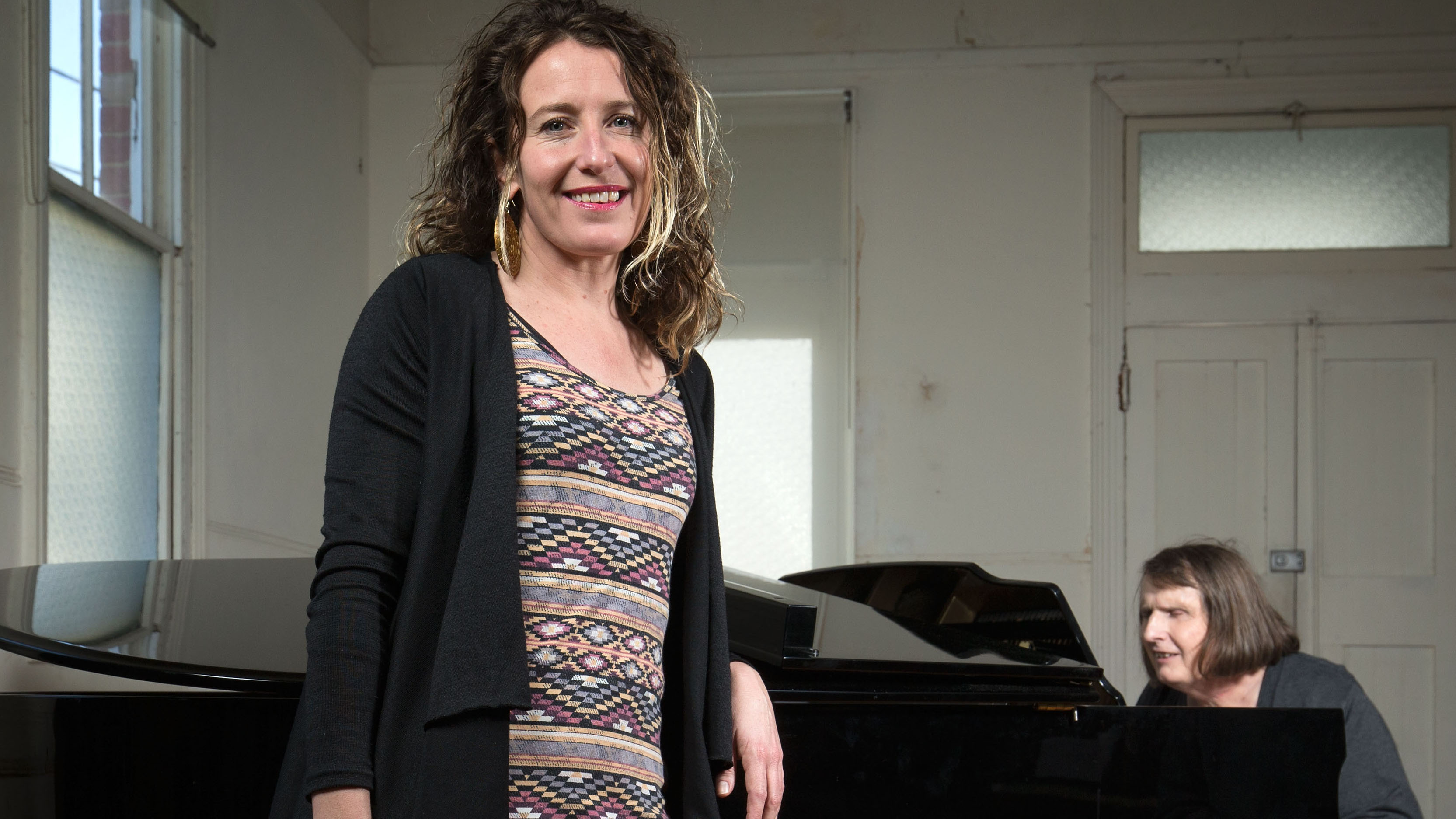 Director Jodee Mundy poses for a photo as deafblind performer Michelle Stevens plays piano on August 16, 2016 in Melbourne, Australia. Her current show 'Imagined Touch' features actors who are deaf and blind.