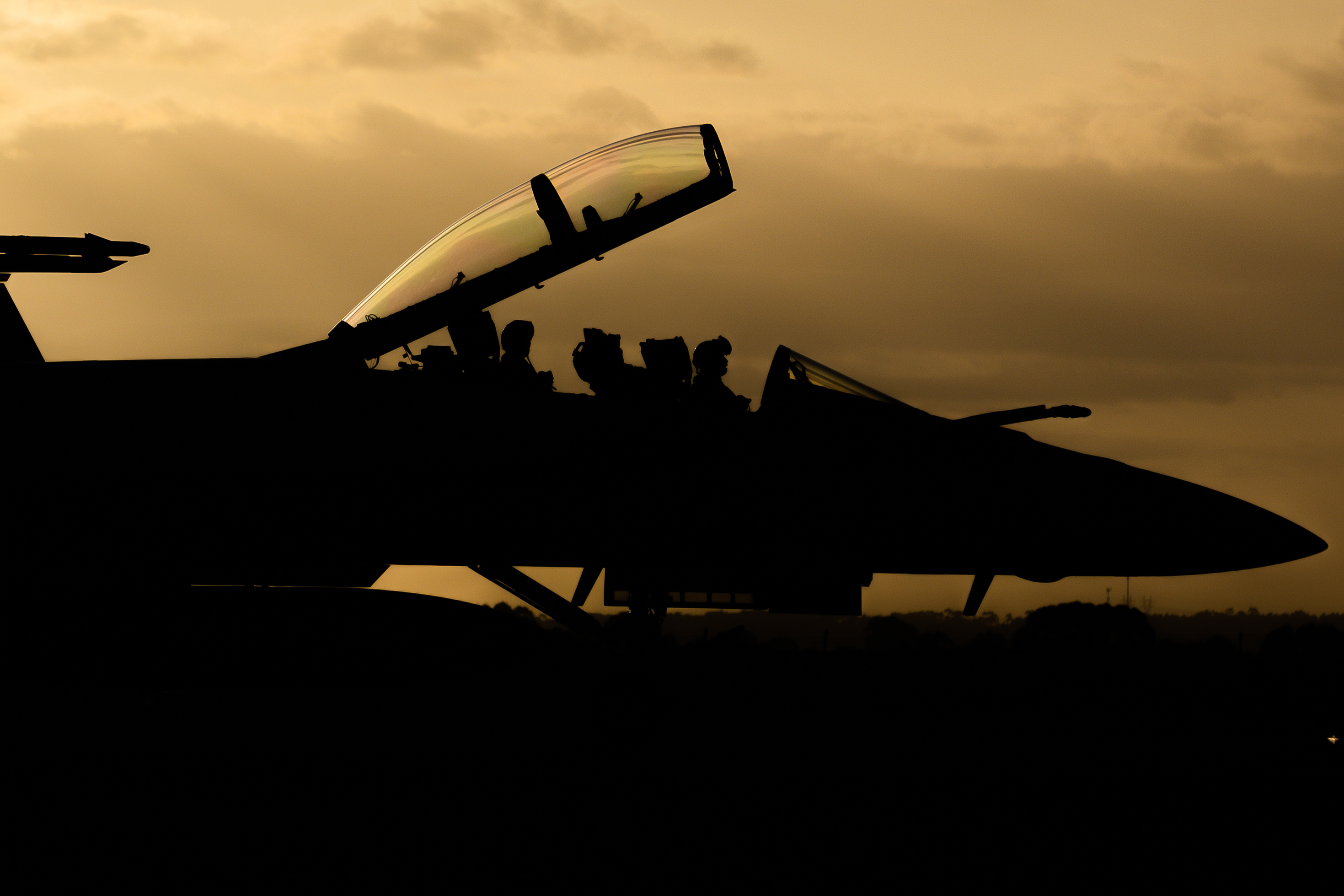 A silhouetted RAAF F/A-18F Super Hornet