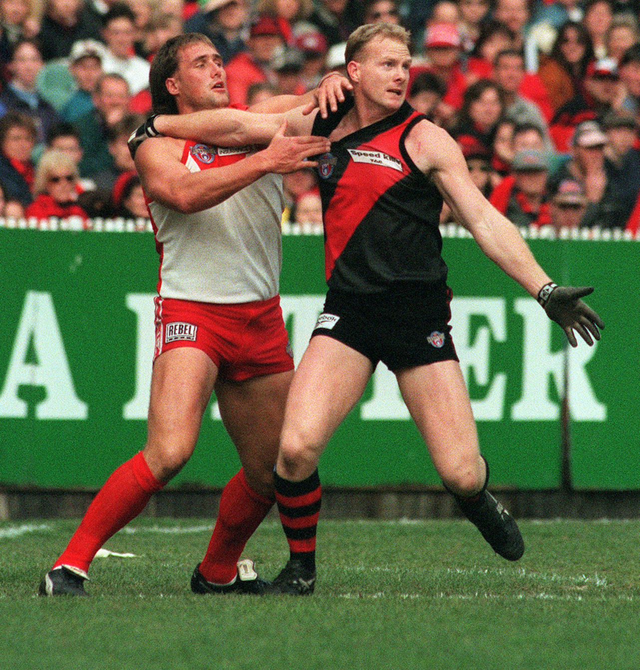 Essendon's Dean Wallis fends off Tony Lockett.