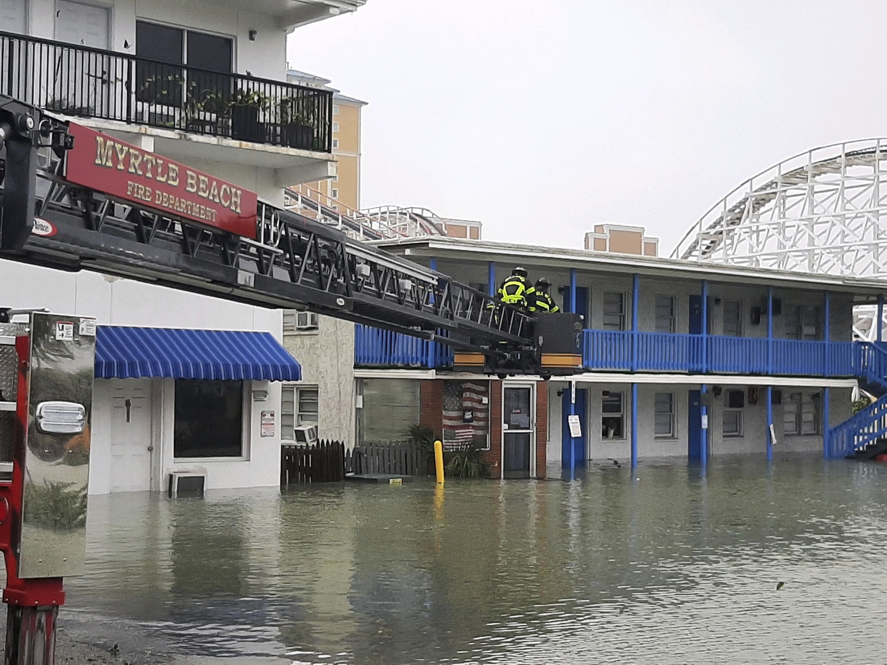This photo provided by the Myrtle Beach Fire Dept., crews respond to rescue people who were trapped on the second floor due to flooding caused by Hurricane Ian, on Friday, Sept. 30, 2022 in Myrtle Beach, S.C. (Myrtle Beach Fire Dept. via AP)