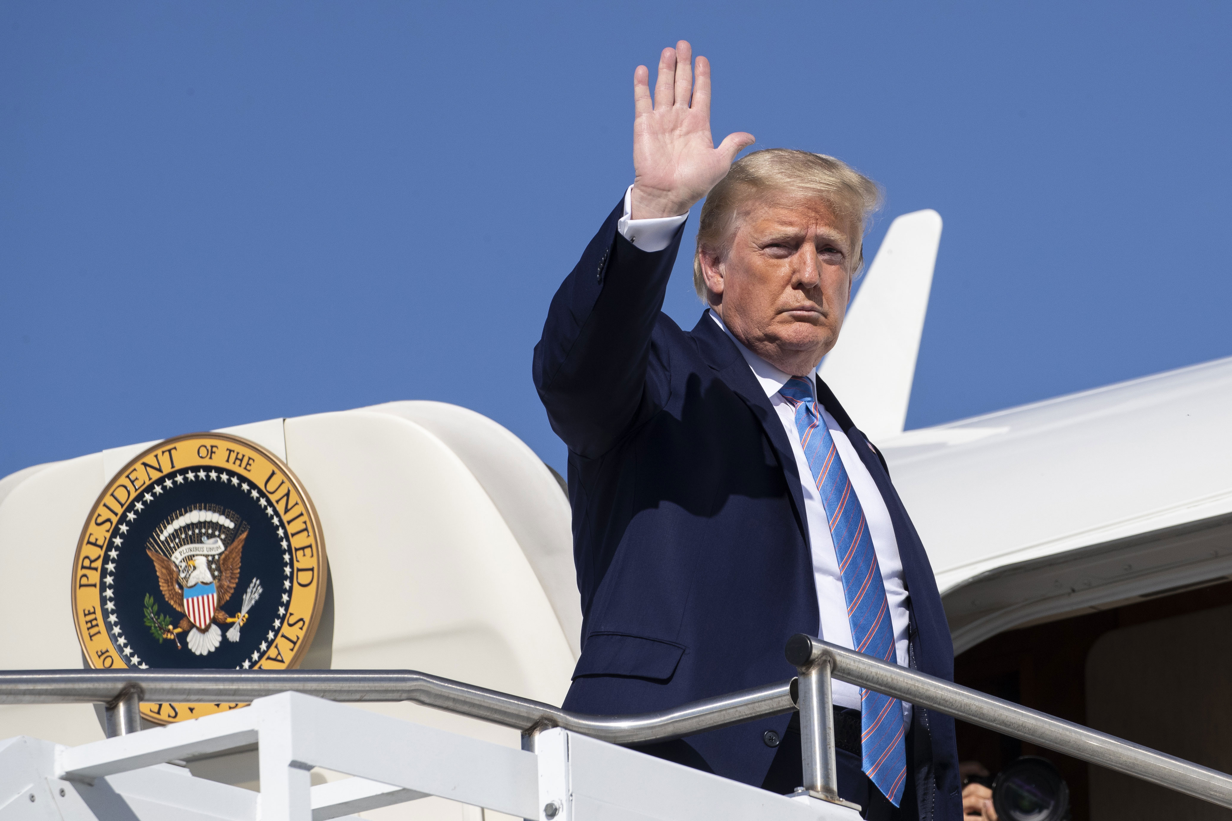 President Donald Trump waves as he boards Air Force One at Morristown Municipal Airport, in New Jersey.