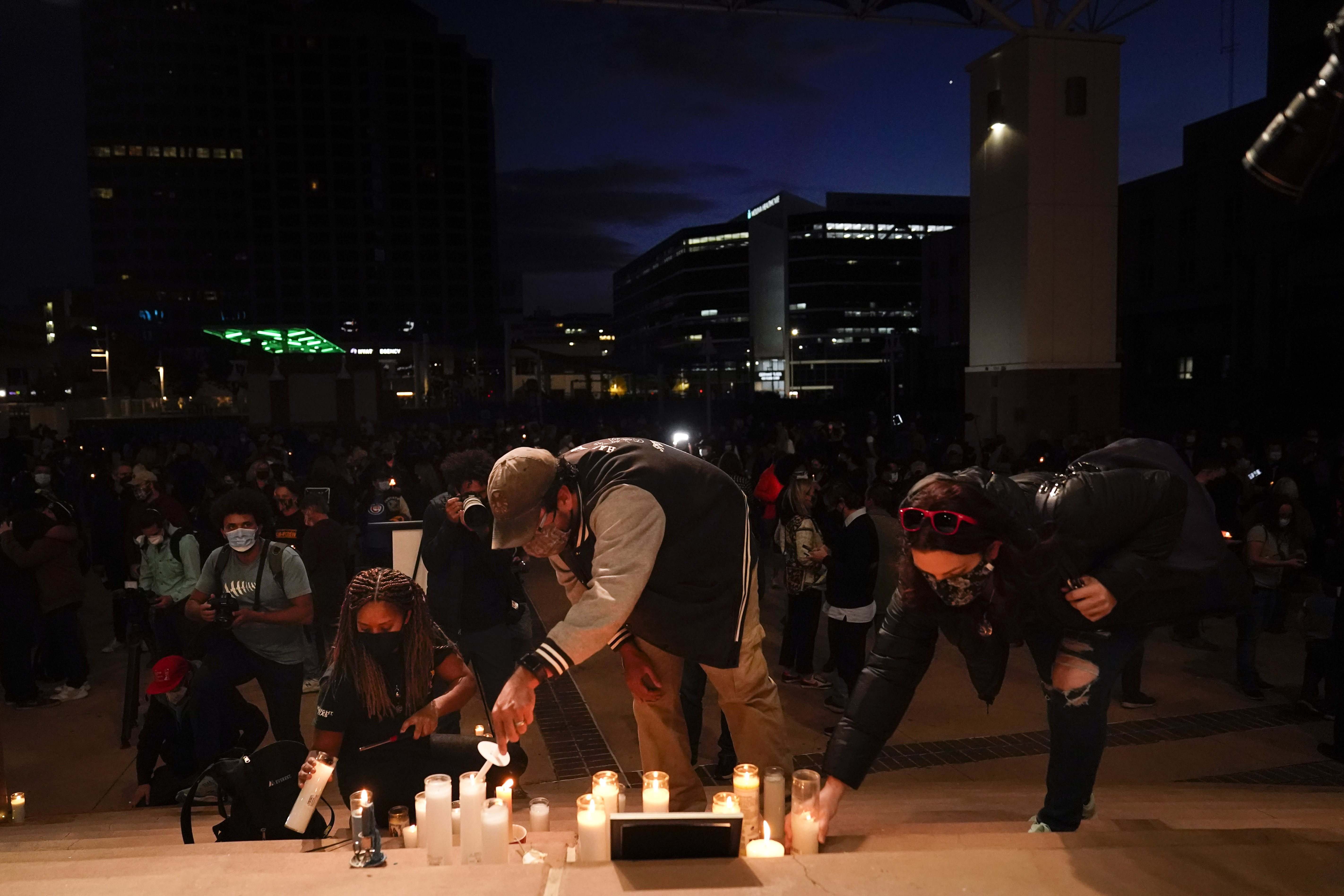 People light candles to honor cinematographer Halyna Hutchins. 