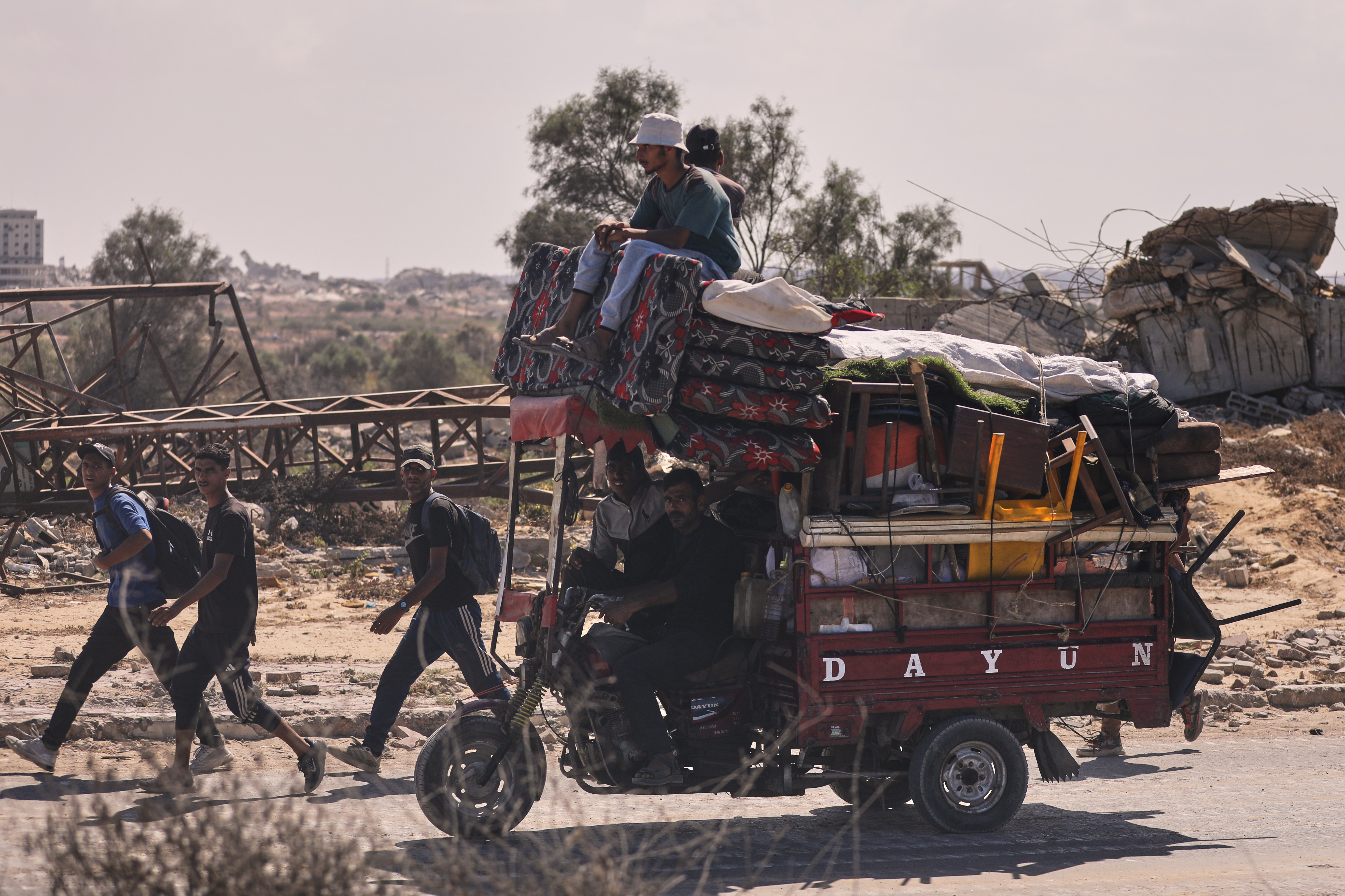 Displaced Palestinians walk along the coastal road as they move in the direction of Gaza City,