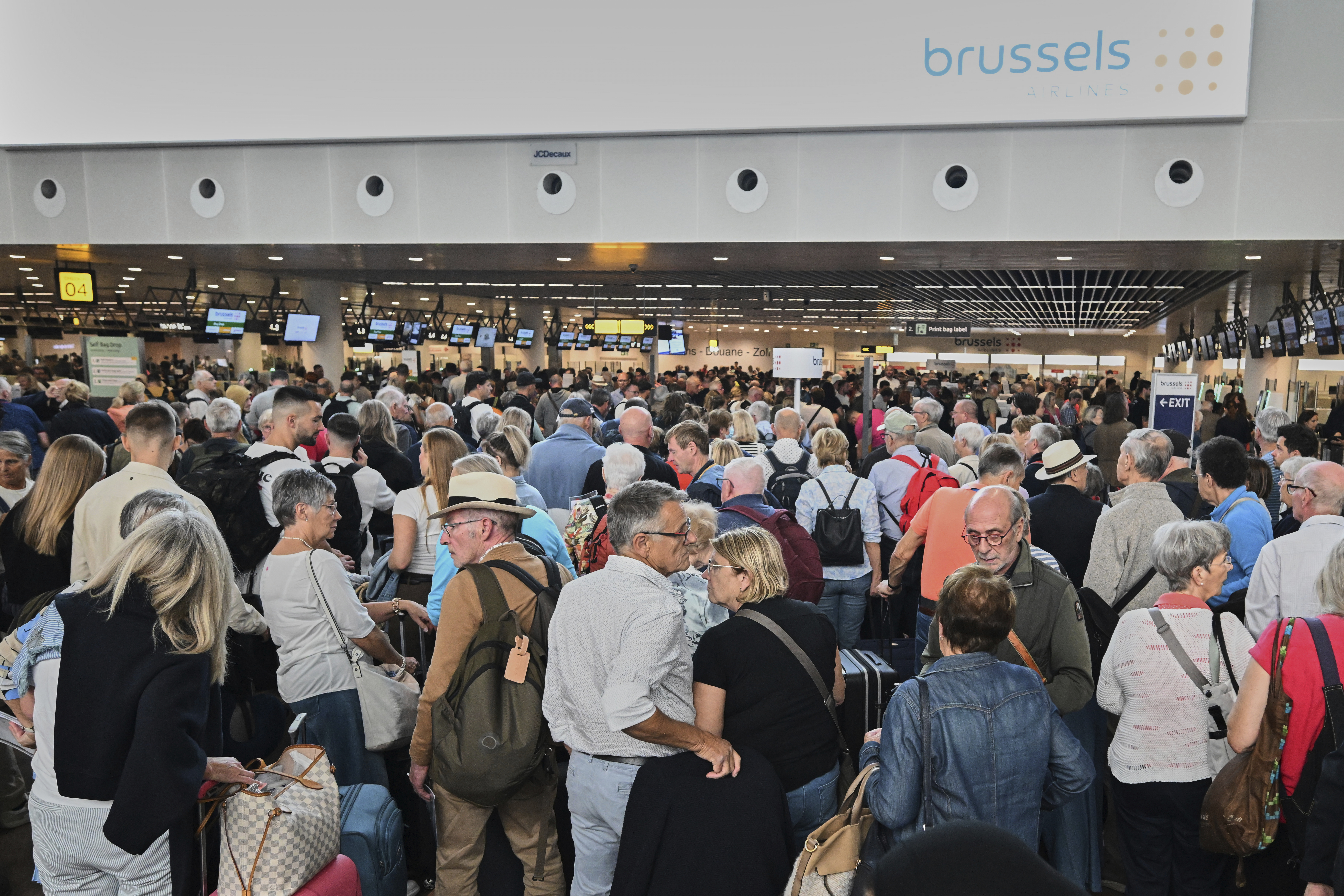 People stand in a line to check in after a cyber attack caused delays at Brussels International Airport in Zaventem, Belgium, Saturday, Sept. 20, 2025. (AP Photo/Harry Nakos)
