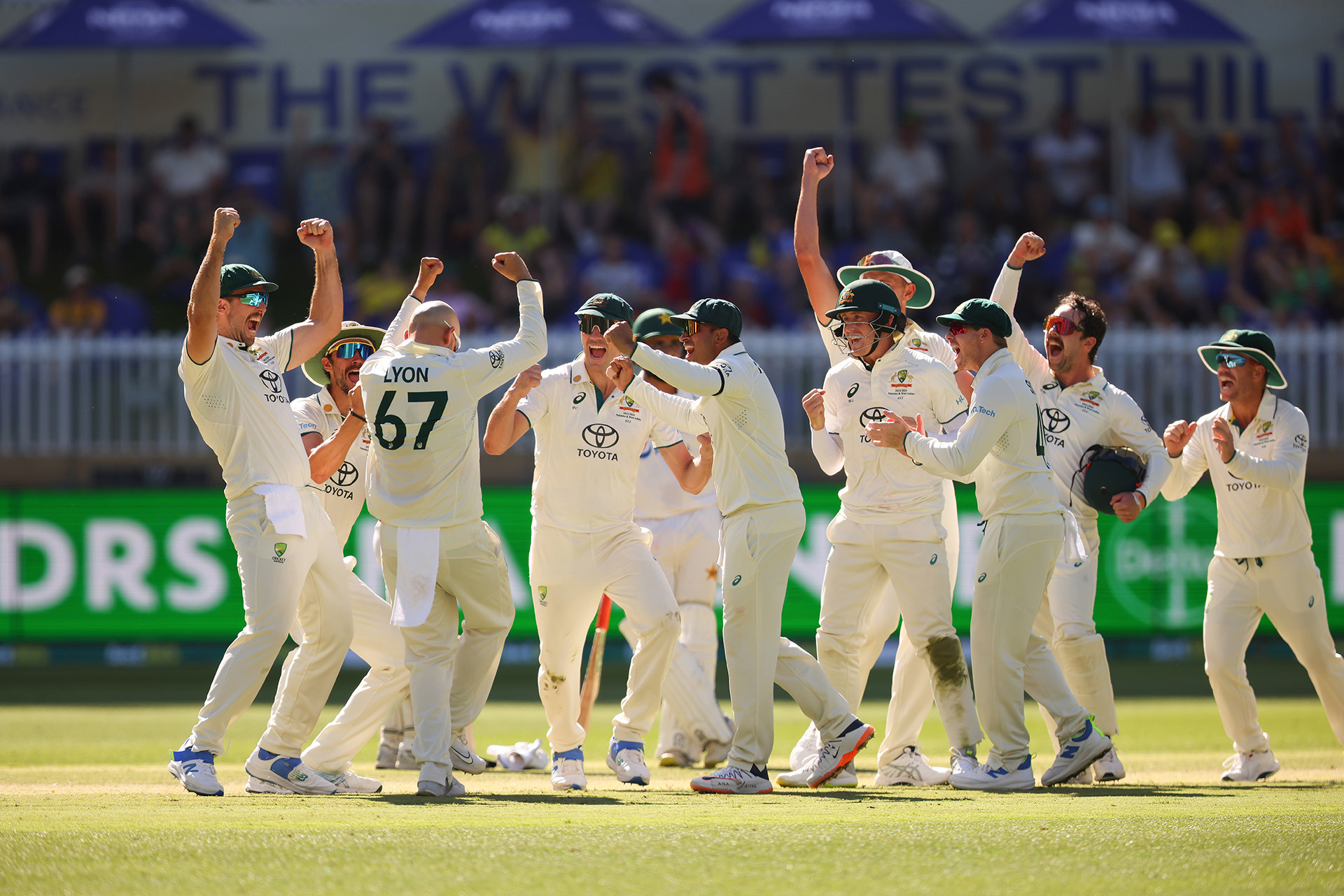 Nathan Lyon of Australia and all of the team celebrate his 500th Test wicket during day four of the first match against Pakistan.