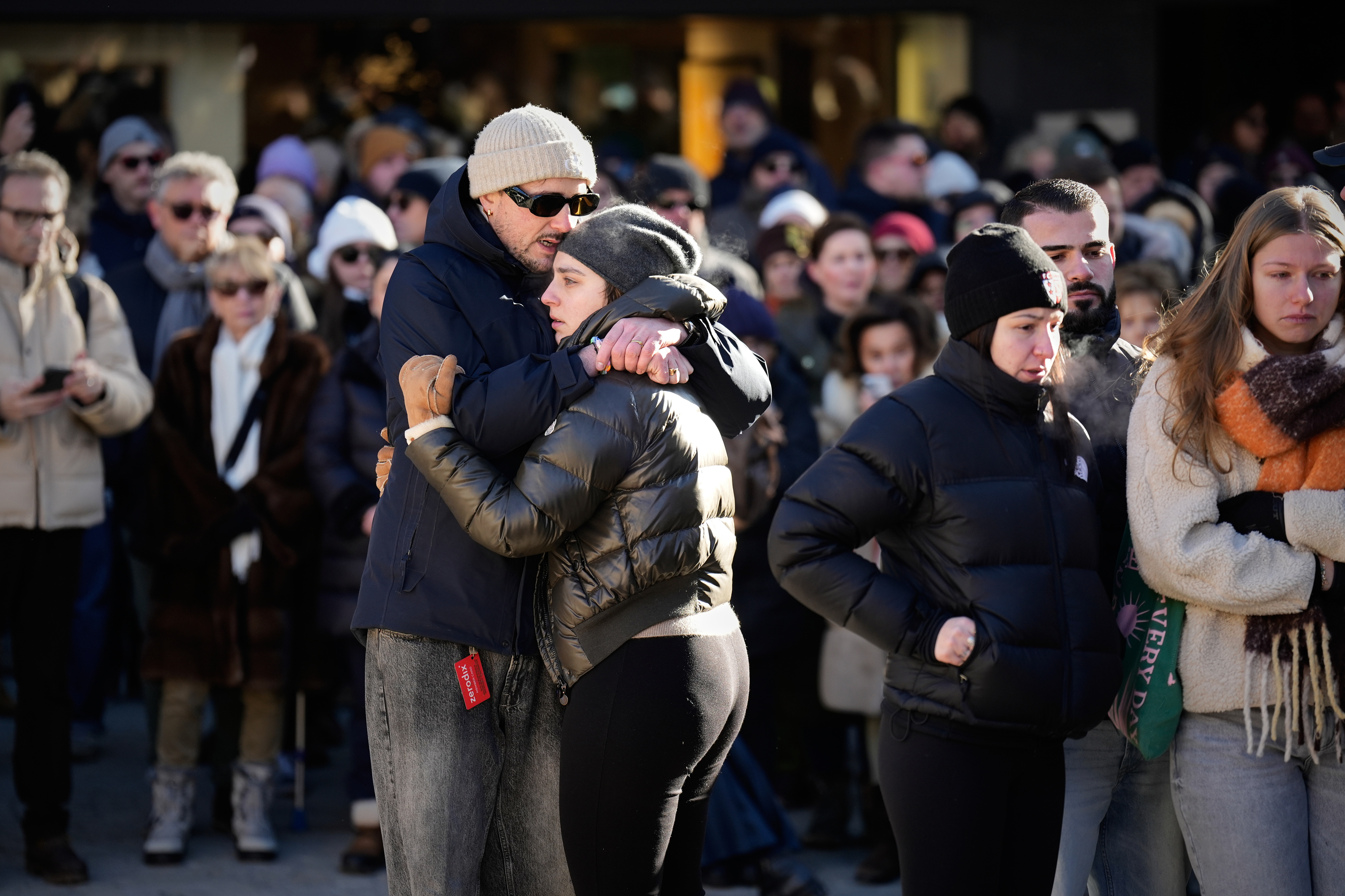 People cry as they attend a memorial procession in Crans-Montana, Swiss Alps, Switzerland, Sunday, Jan. 4, 2026, after a devastating fire in Le Constellation bar left dead and injured during the New Year's celebrations. (AP Photo/Baz Ratner)