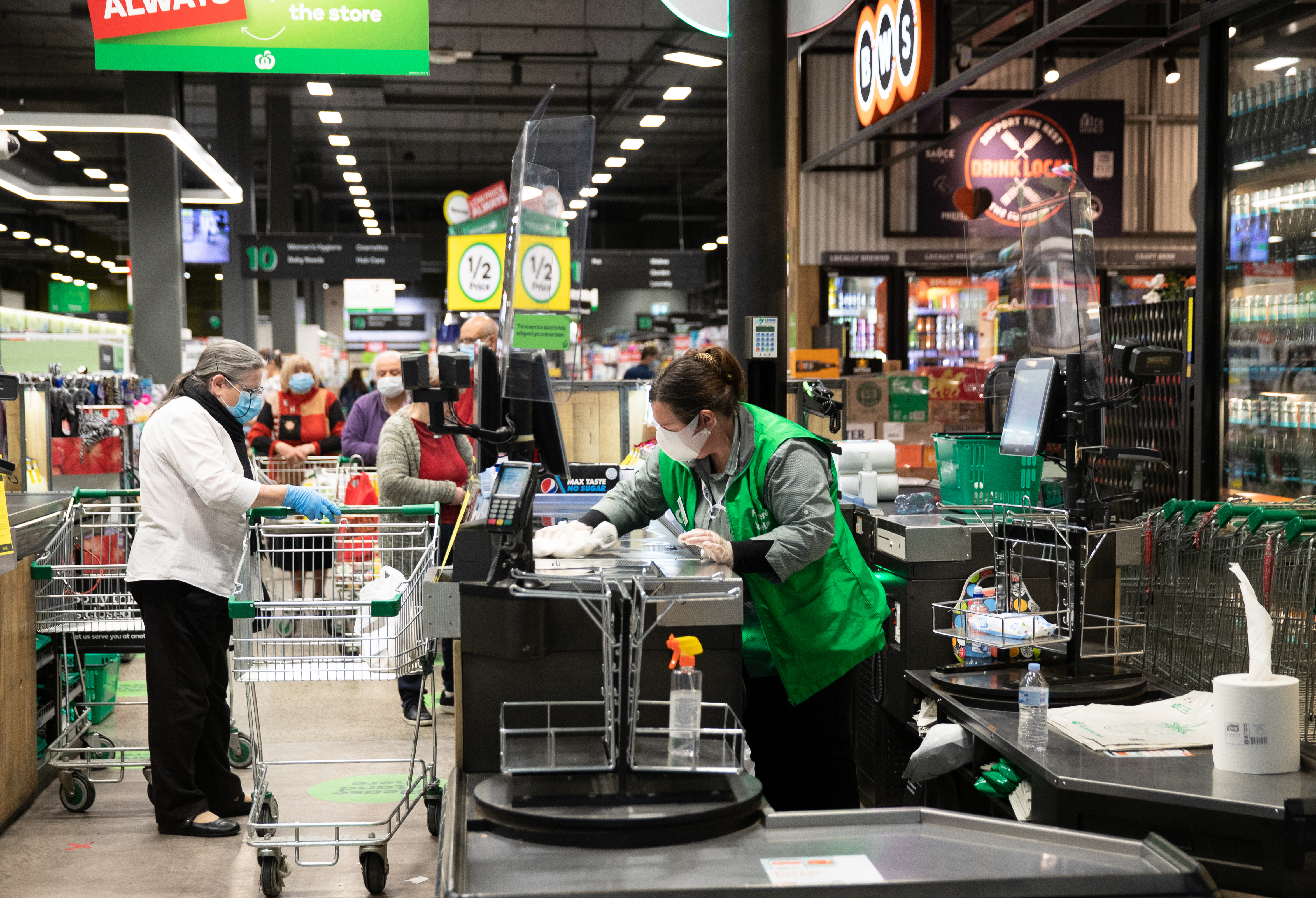 A staff member wipes down the checkout area at Woolworths 