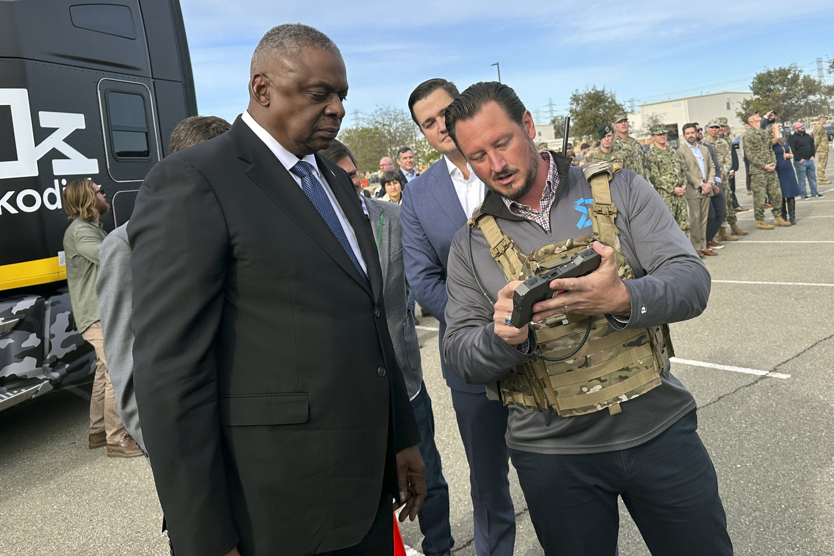 Defence Secretary Lloyd Austin takes a closer look at the device used to control a swarm of drones that lifted off from a parking area at the Defense Innovation Unit in Mountain View, Calif, on Friday, Dec. 1, 2023. 
