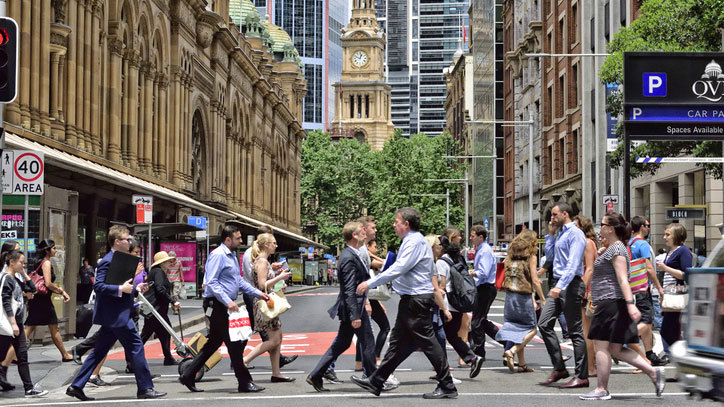 Workers cross the street in Sydney's CBD. 