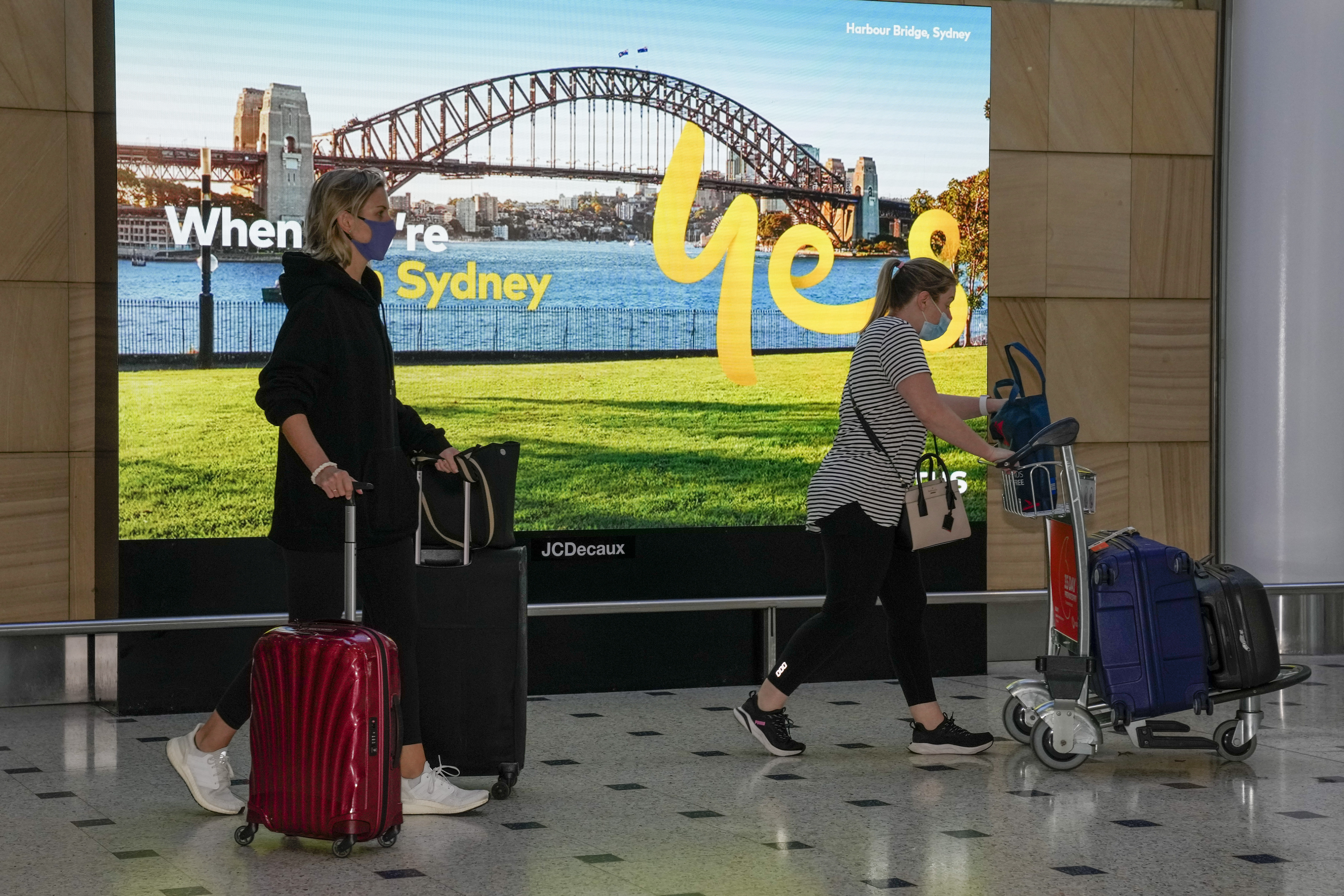 Passengers arrive early morning at Sydney Airport, Monday, Nov. 29, 2021. Authorities in Australia said Sunday, Nov. 28, 2021, that two travelers who arrived in Sydney from Africa became the first in the country to test positive for the new variant of the coronavirus, omicron. (AP Photo/Mark Baker)