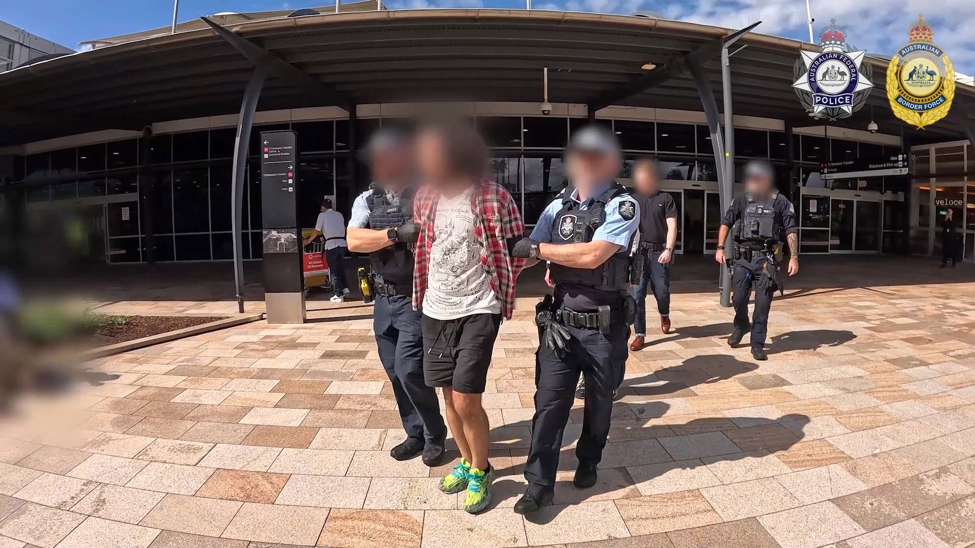 Drug dog sits next to suitcase at Sydney Airport, sparking major find