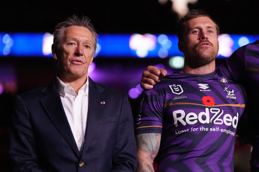 Craig Bellamy, head coach of the Storm (L) and Cameron Munster sing the national anthem.