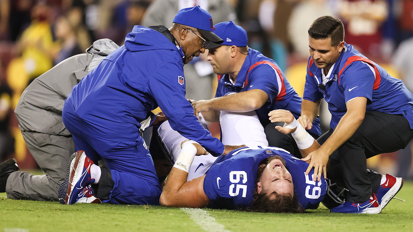 Nick Gates of the New York Giants is treated after suffering a horror broken leg against Washington.