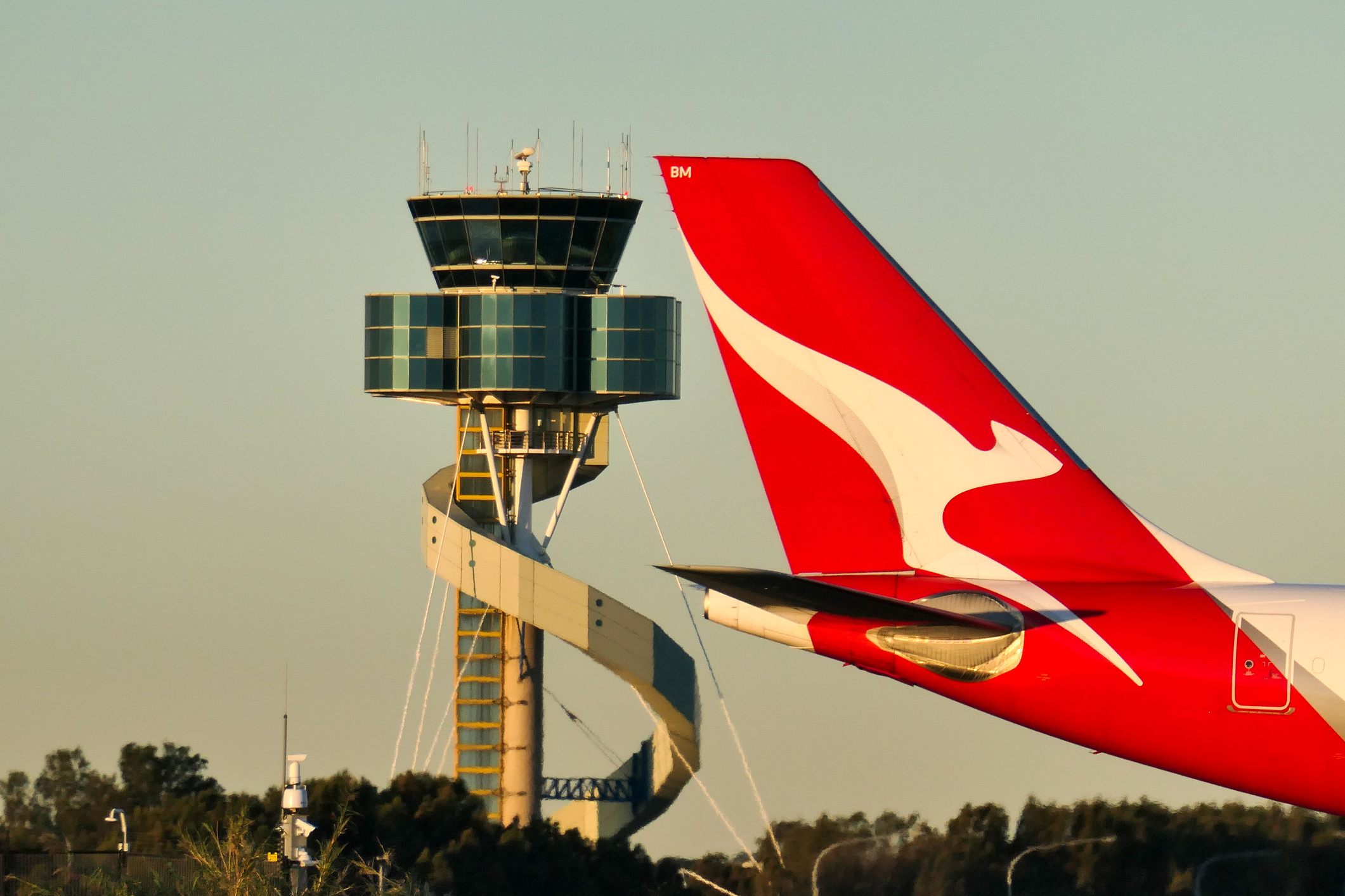 A Qantas Airbus A330-202 plane, registration VH-EBM, passing the air traffic control tower as she taxis at Sydney Kingsford-Smith Airport in preparation for departure as flight QF43 to Denpasar. 