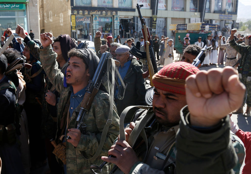 Manifestantes yemeníes leales al movimiento hutí levantan sus rifles mientras participan en una protesta contra la guerra en curso de Israel en Gaza.