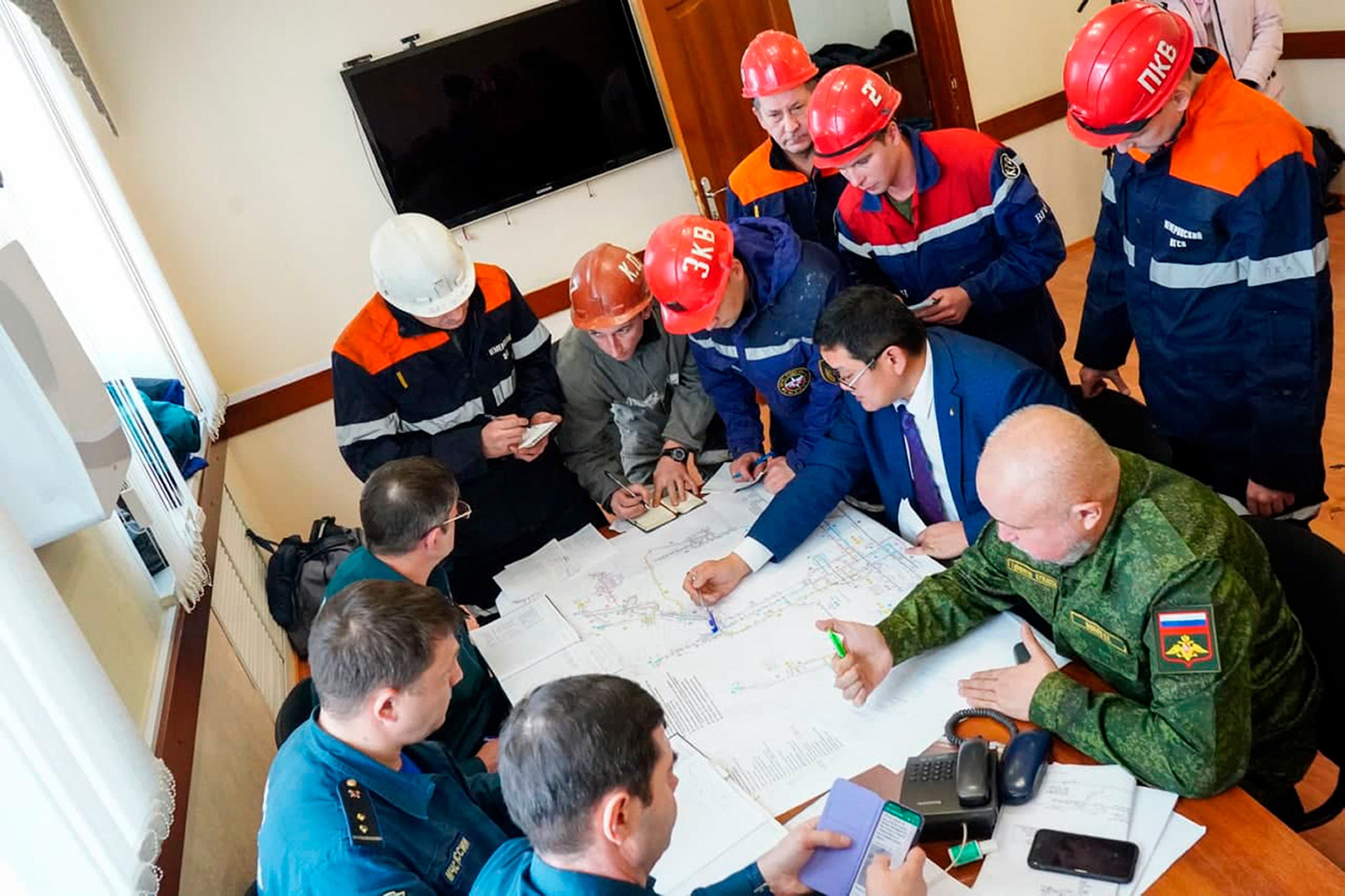 Rescuers and officials attend a meeting, after the accident at the Listvyazhnaya coal mine