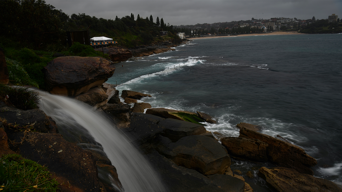 Storm water runs off the cliffs behind Wiley's Baths in Coogee today after a cold weather front passing through Sydney lowed the temperatures by 10 degrees or more and brought Rain with it.
