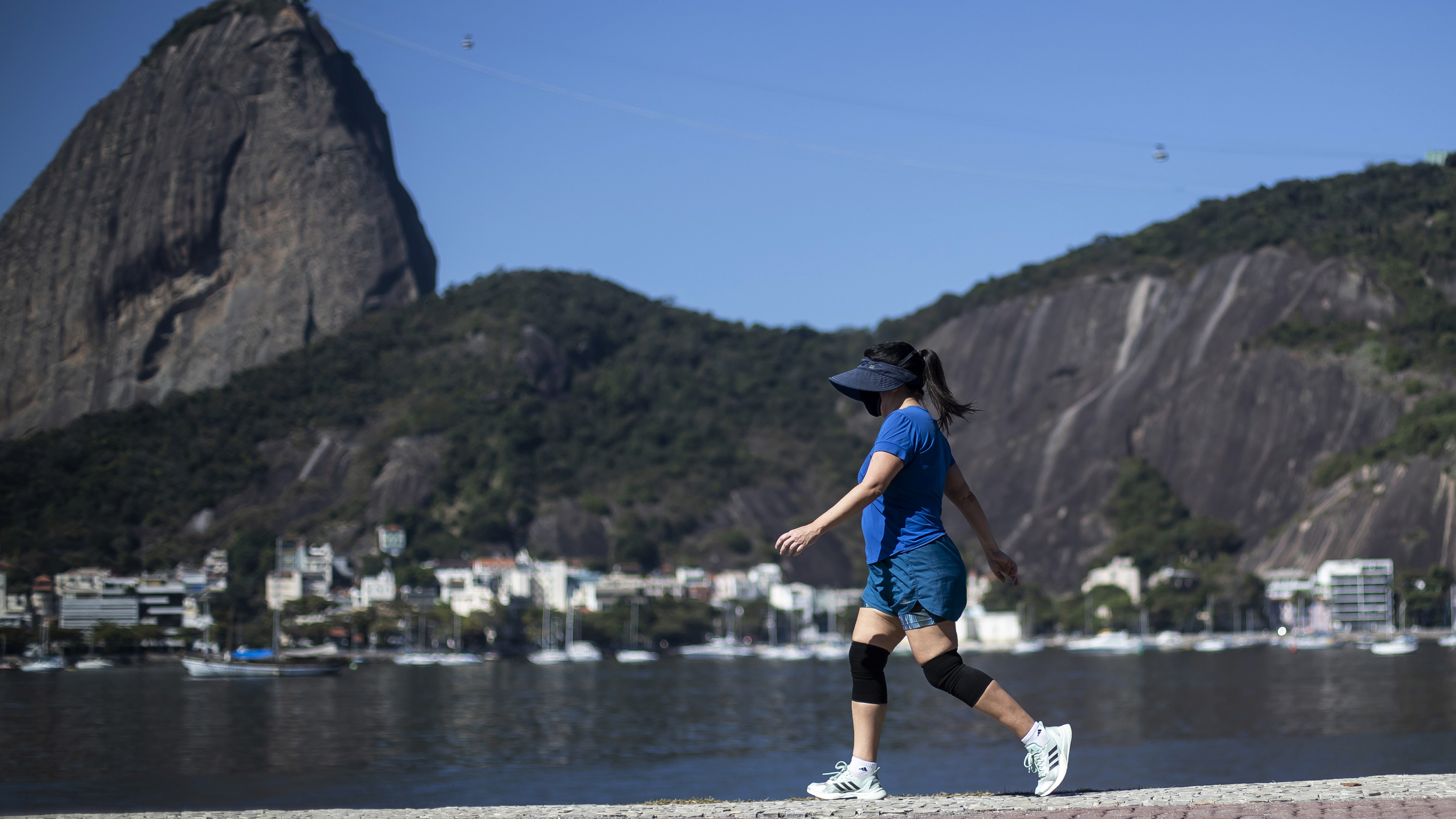 A woman walks past Sugarloaf Mountain in Rio de Janeiro, Brazil.