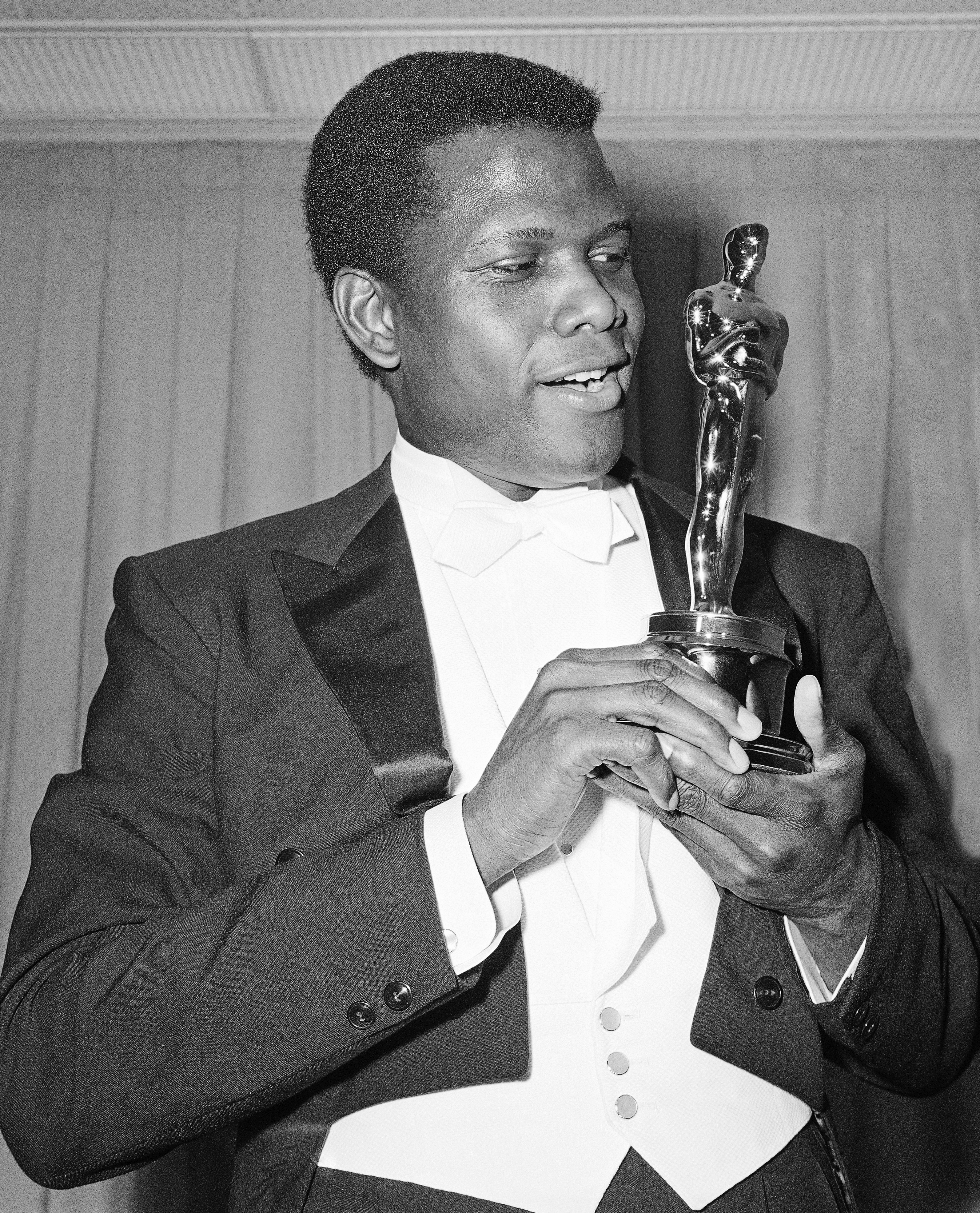 Actor Sidney Poitier poses with his Oscar for best actor for "Lillies of the Field" at the 36th Annual Academy Awards in Santa Monica, Calif. on April 13, 1964.  