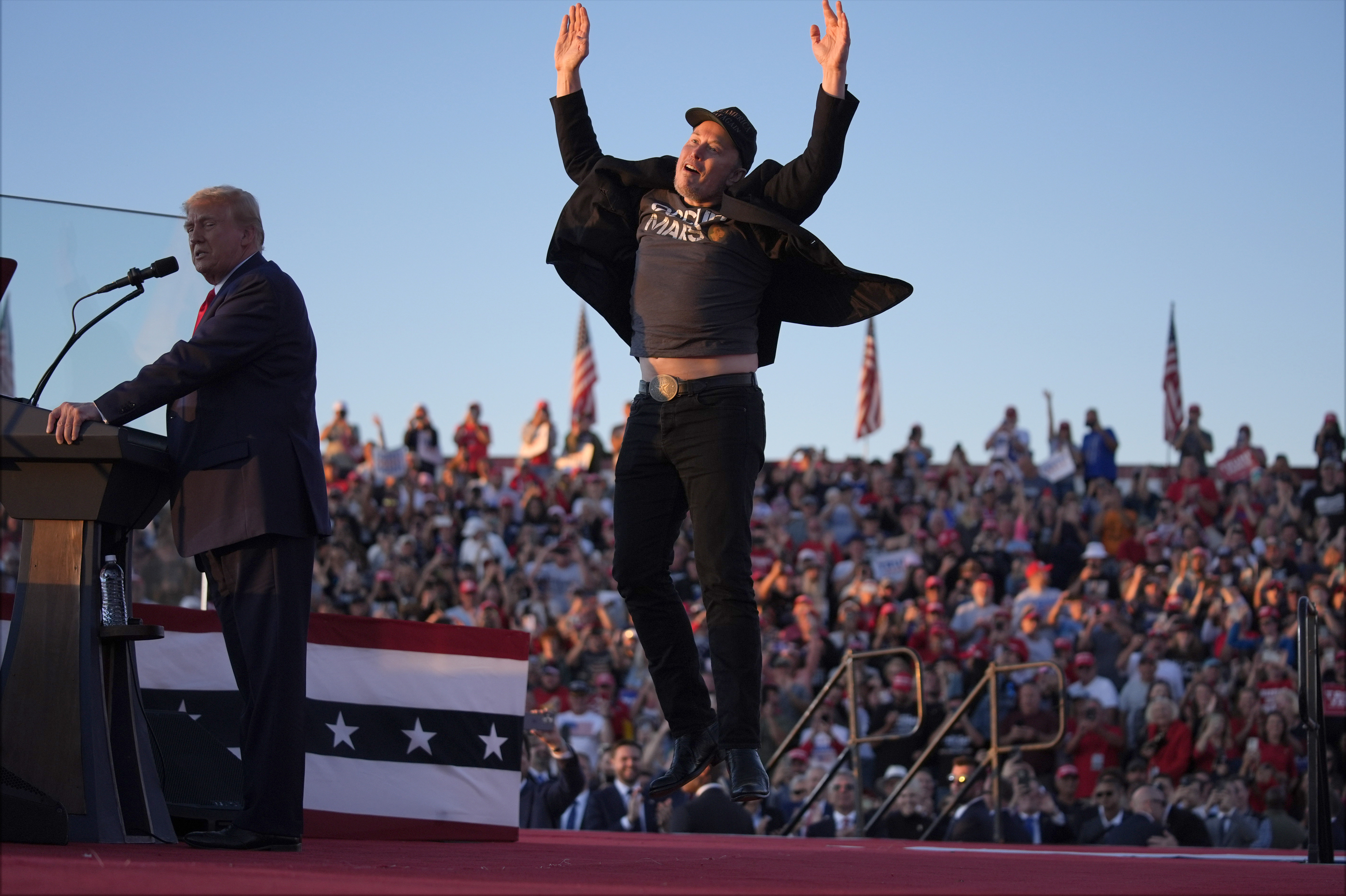 Elon Musk salta al escenario mientras el expresidente Donald Trump, candidato presidencial republicano, habla en un mitin de campaña en el Butler Farm Show, el sábado 5 de octubre de 2024, en Butler, Pensilvania. 