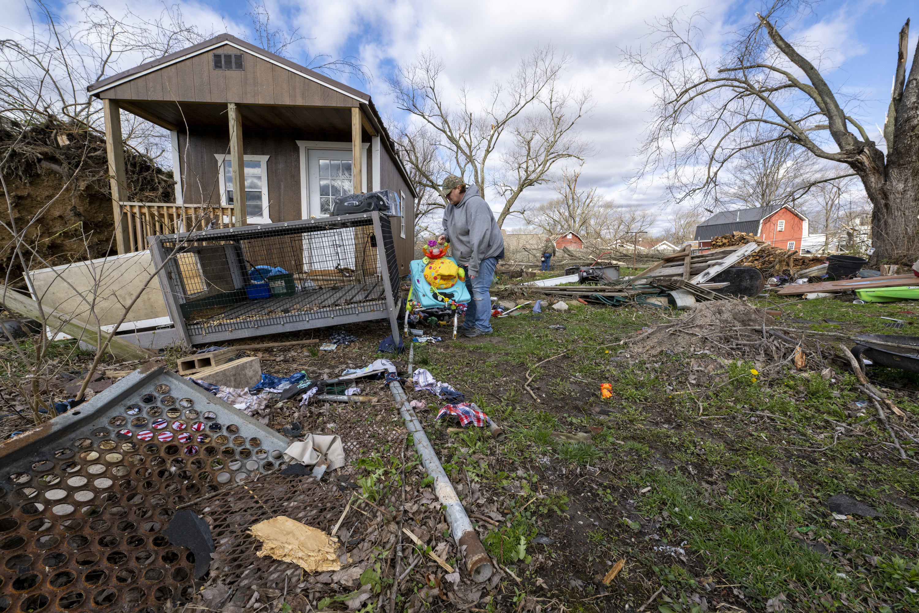 Misty Grimes, busca entre los escombros esparcidos por su patio dejados por un tornado nocturno en Sullivan, Indiana, el sábado 1 de abril de 2023.